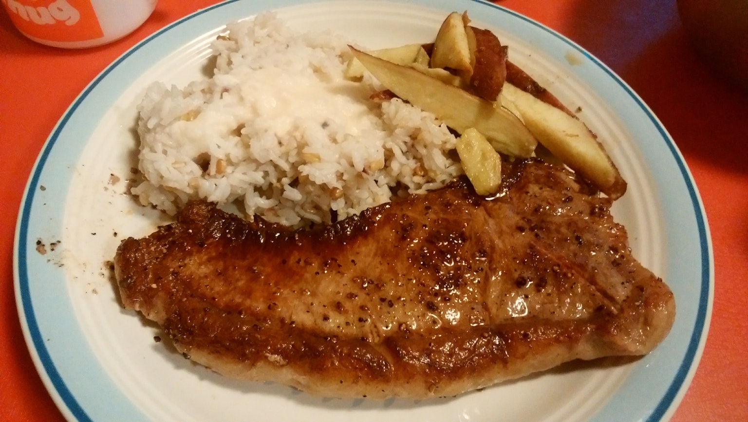 Steak juteux servi avec de la purée de pommes de terre crémeuse et des pommes tranchées sur une assiette