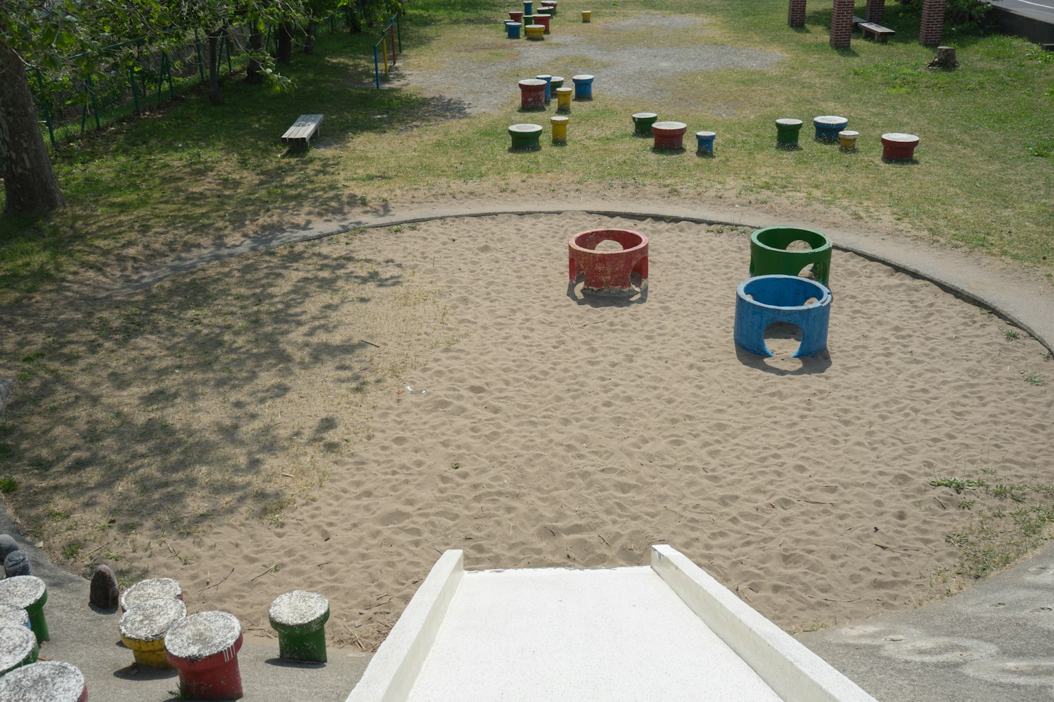 Vue d'un terrain de jeux avec une aire de sable et des équipements colorés