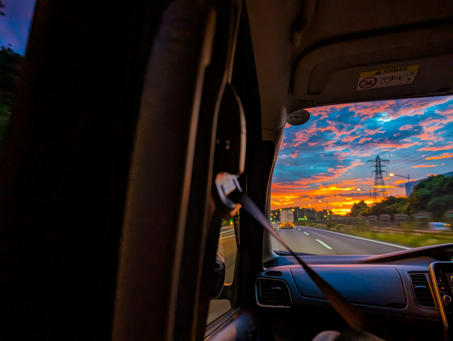 車の窓から見える夕焼けの風景と道路