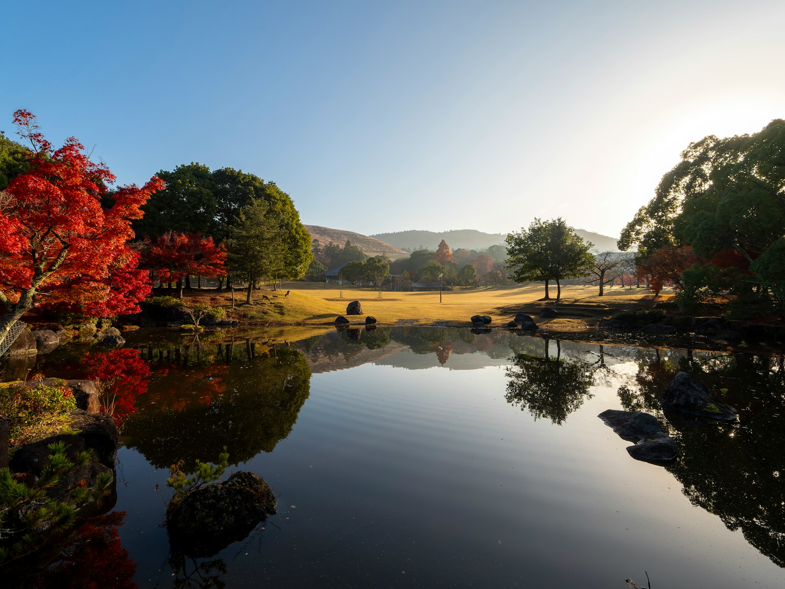 Serene lake reflecting autumn foliage and distant mountains