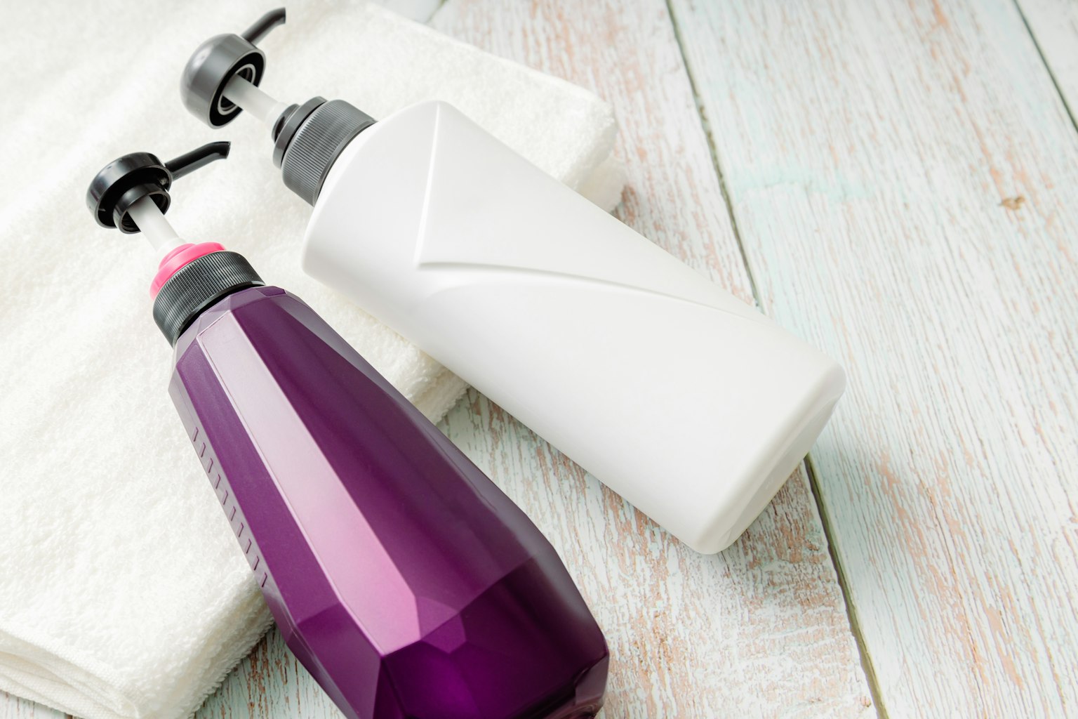 Botellas morada y blanca colocadas sobre una toalla