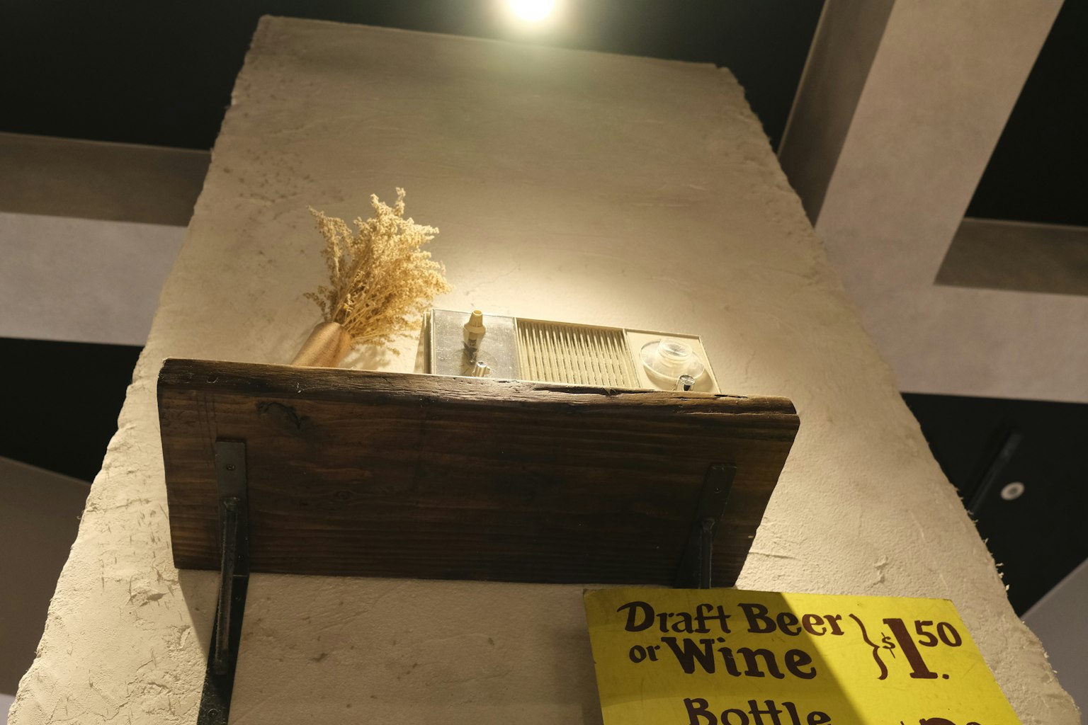 Estante de madera en la pared con hierba seca y objetos decorativos
