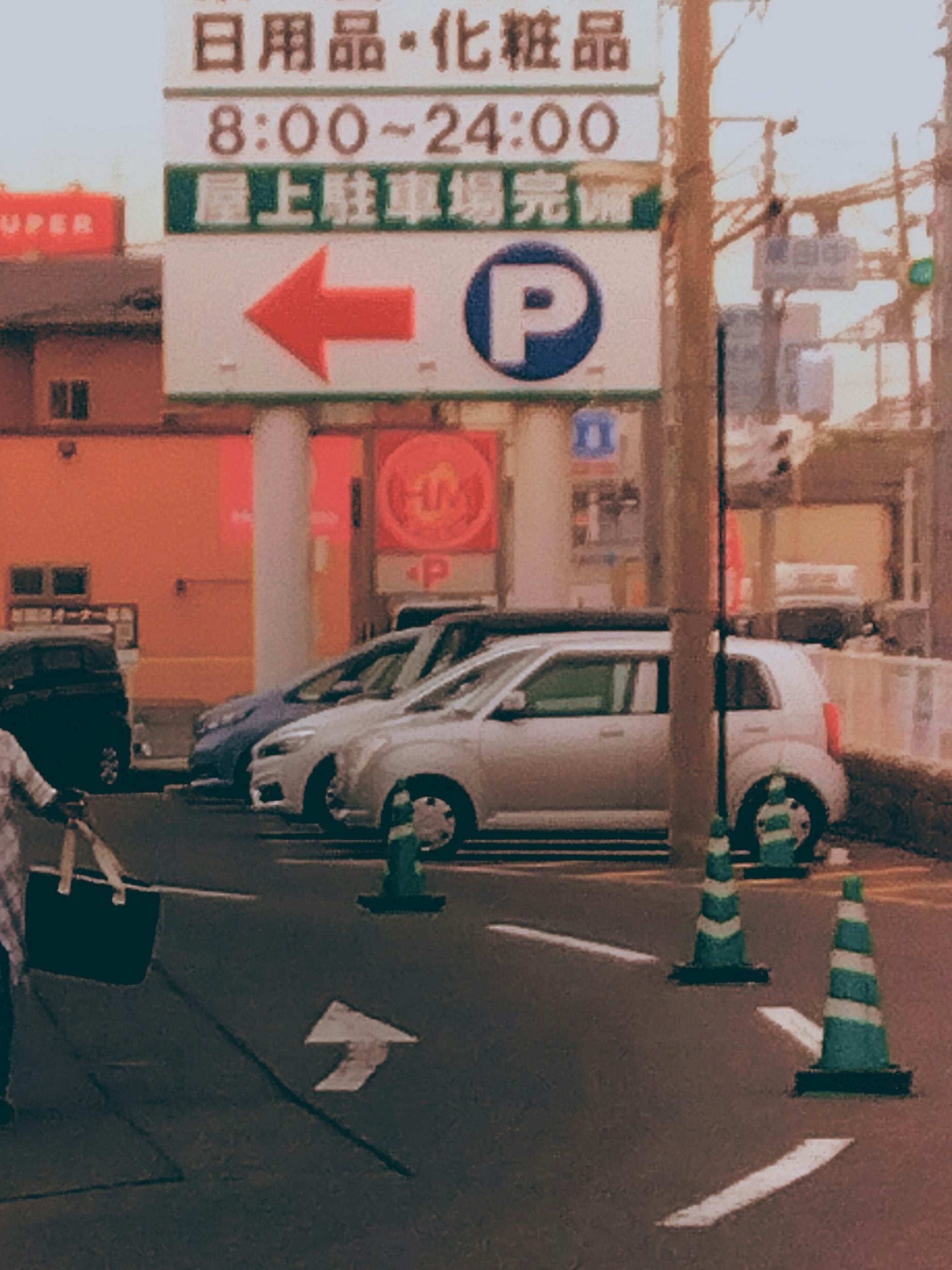 Esquina de calle con coches estacionados y señales de tráfico