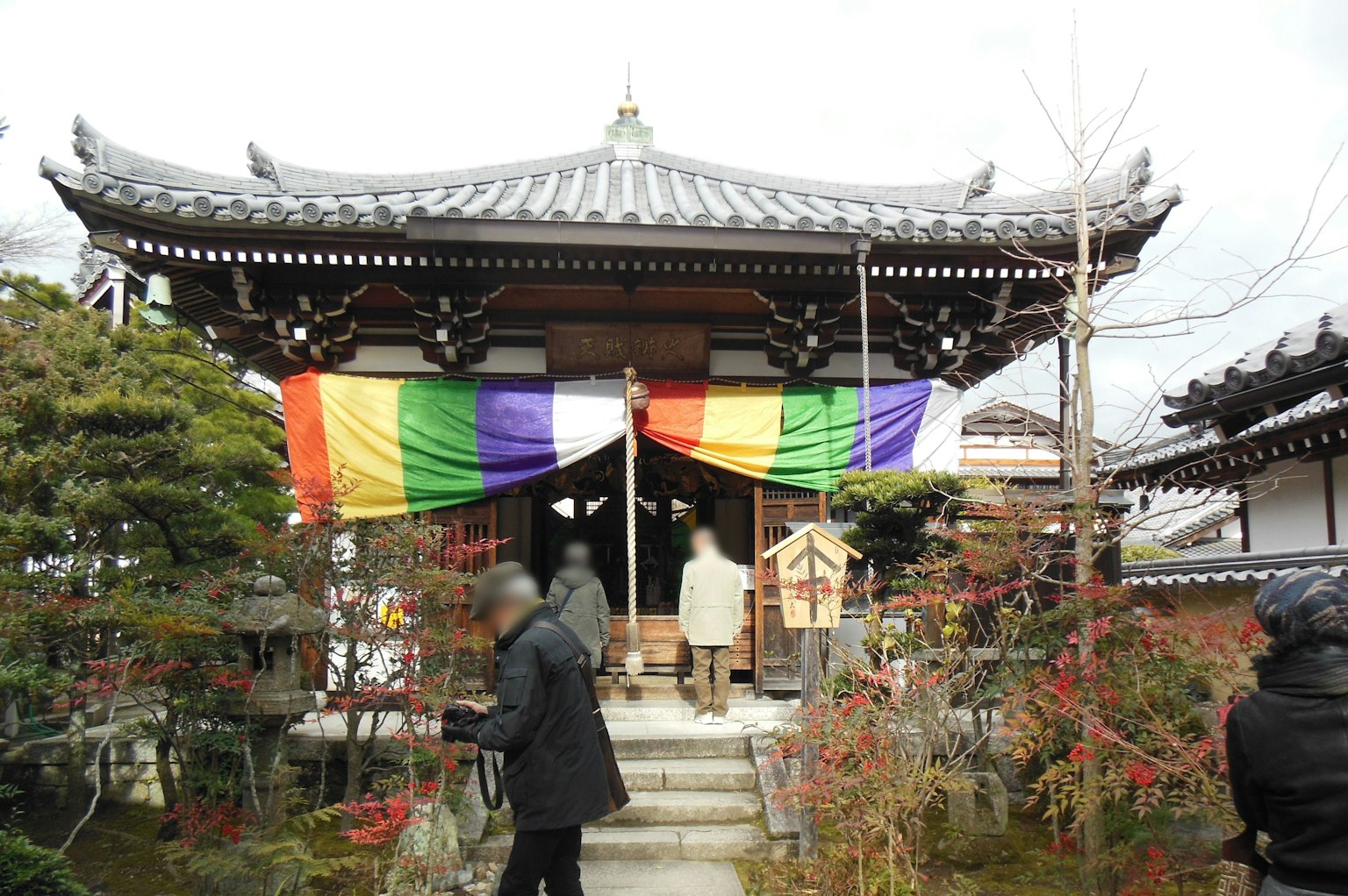 寺庙入口装饰有五彩斑斓的彩虹旗和游客