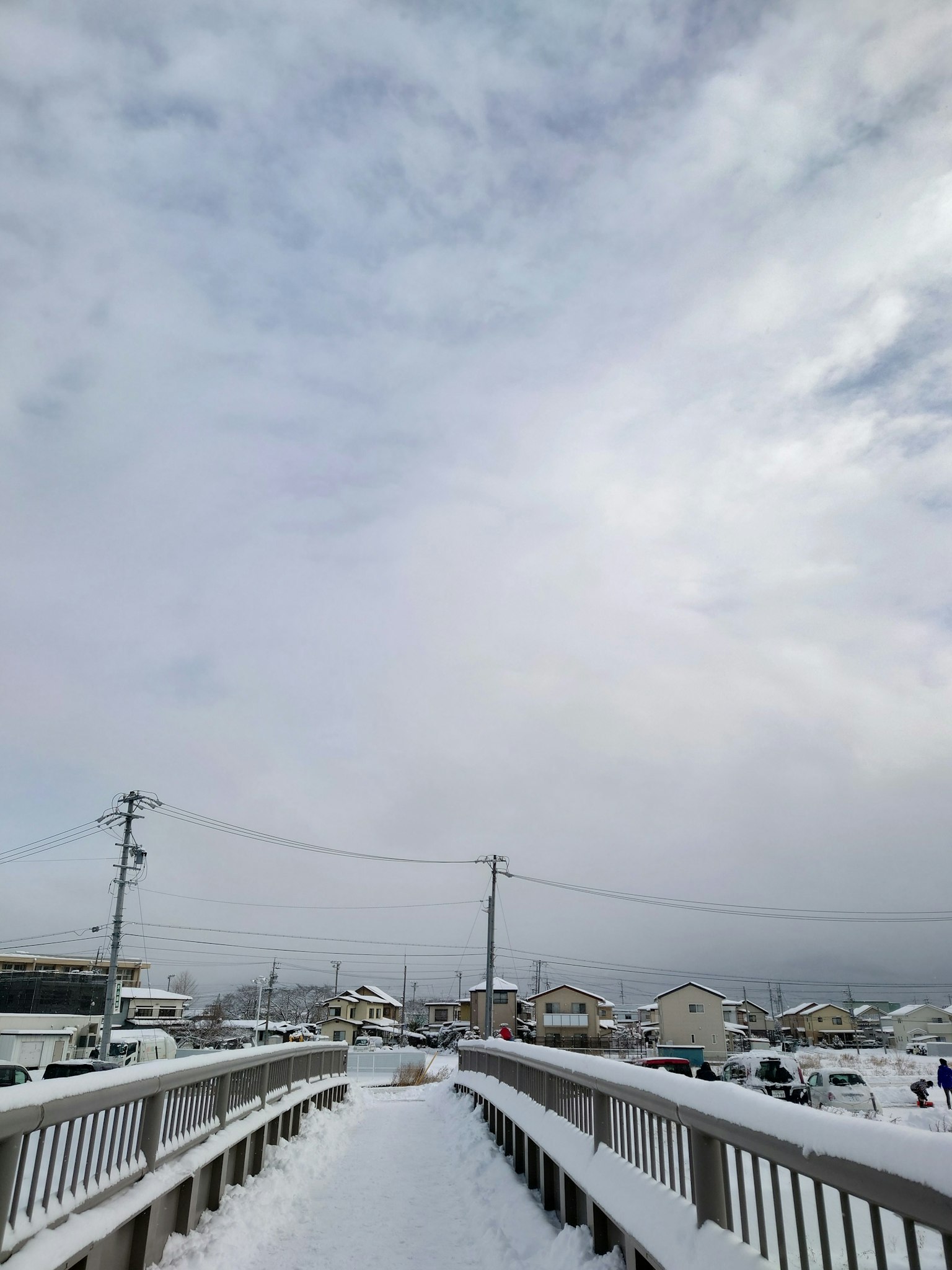 Ponte pedonale coperto di neve con nuvole basse