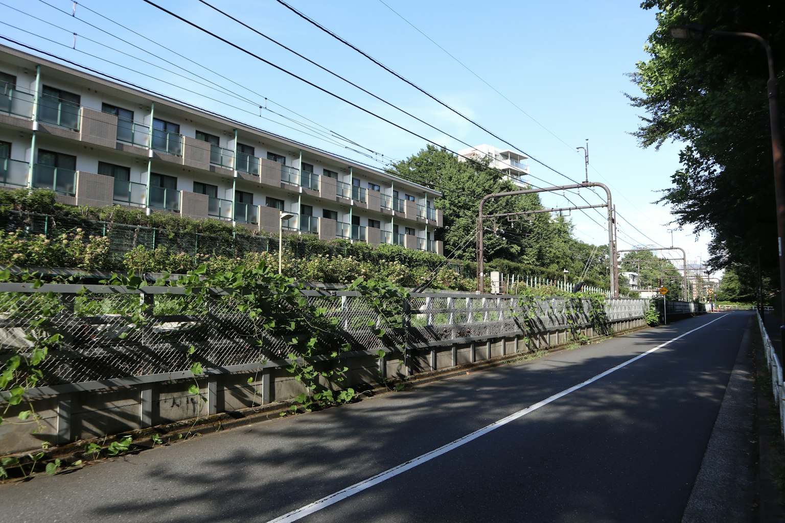 Landscape with an apartment building and greenery under a blue sky