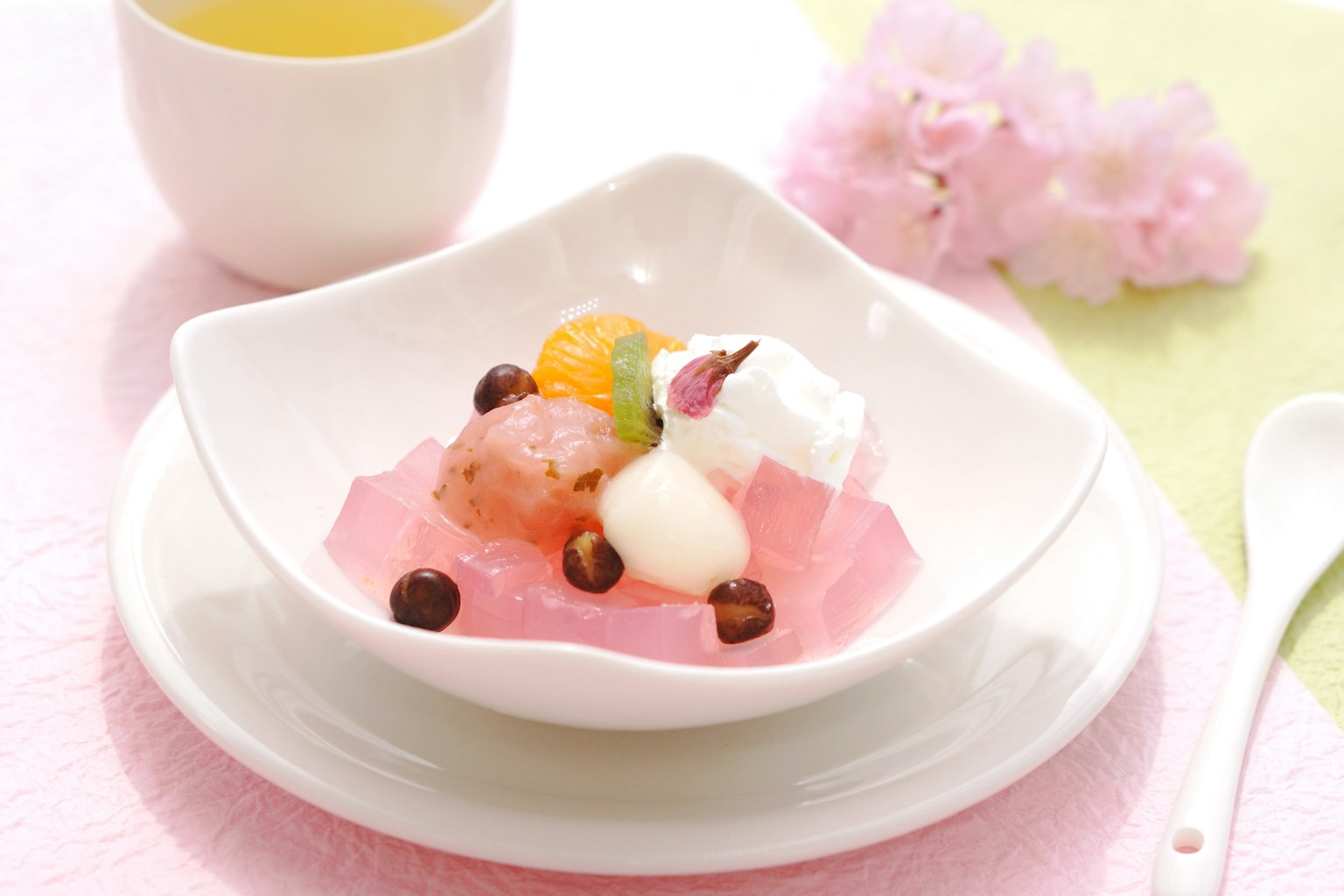 Japanisches Dessert mit rosa Gelee, garniert mit Früchten und Schlagsahne