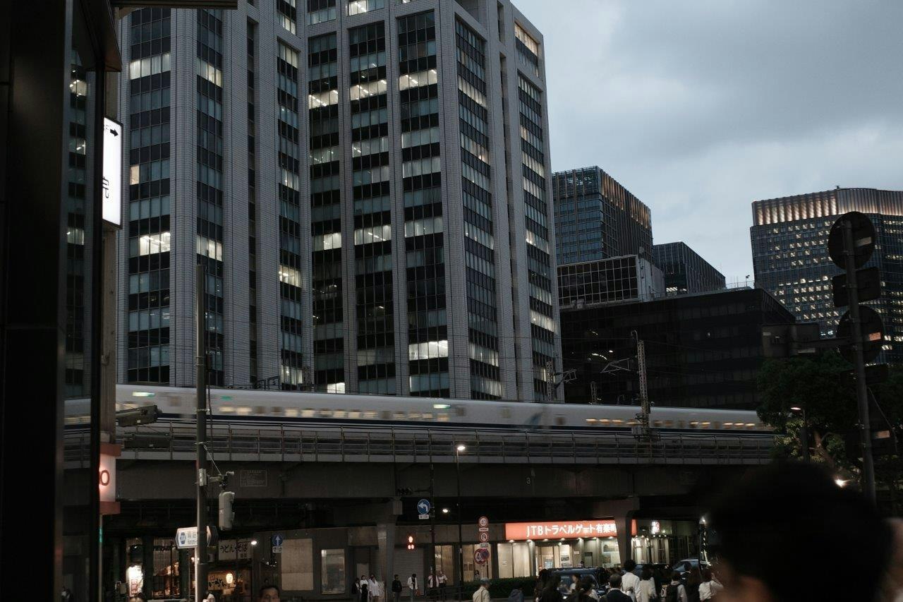 高層ビルに囲まれた高架のある都心の駅前風景