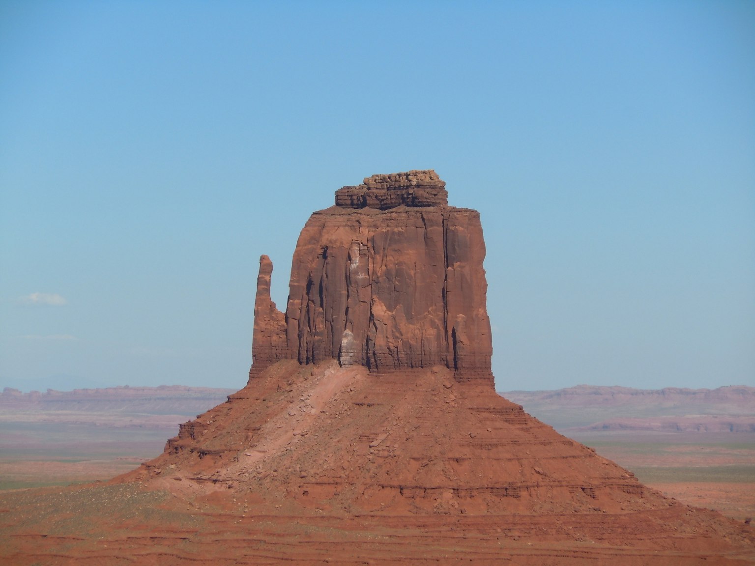 Formation rocheuse rouge de Monument Valley sous un ciel bleu clair