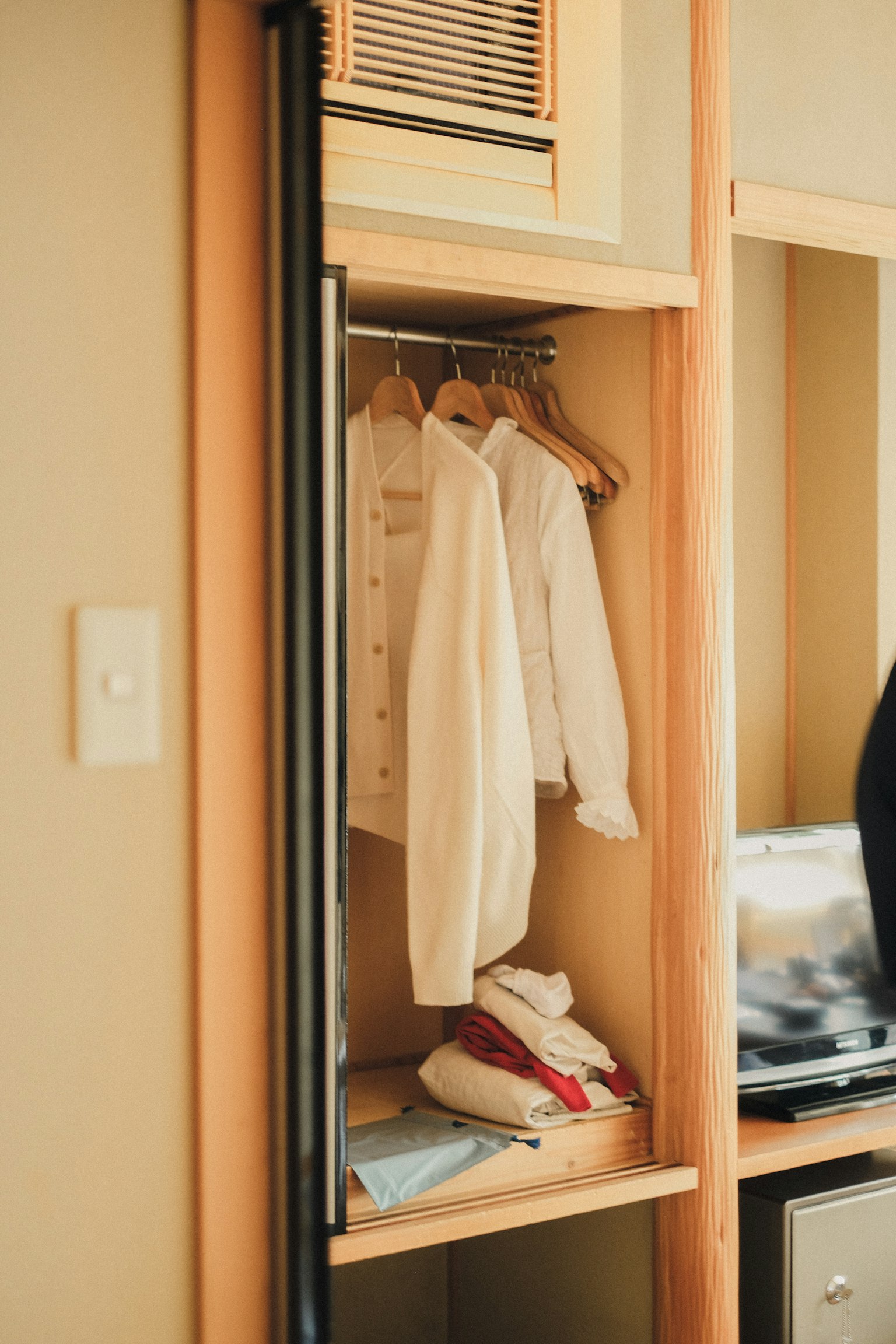 Intérieur d'un placard avec des vêtements suspendus et des chaussures