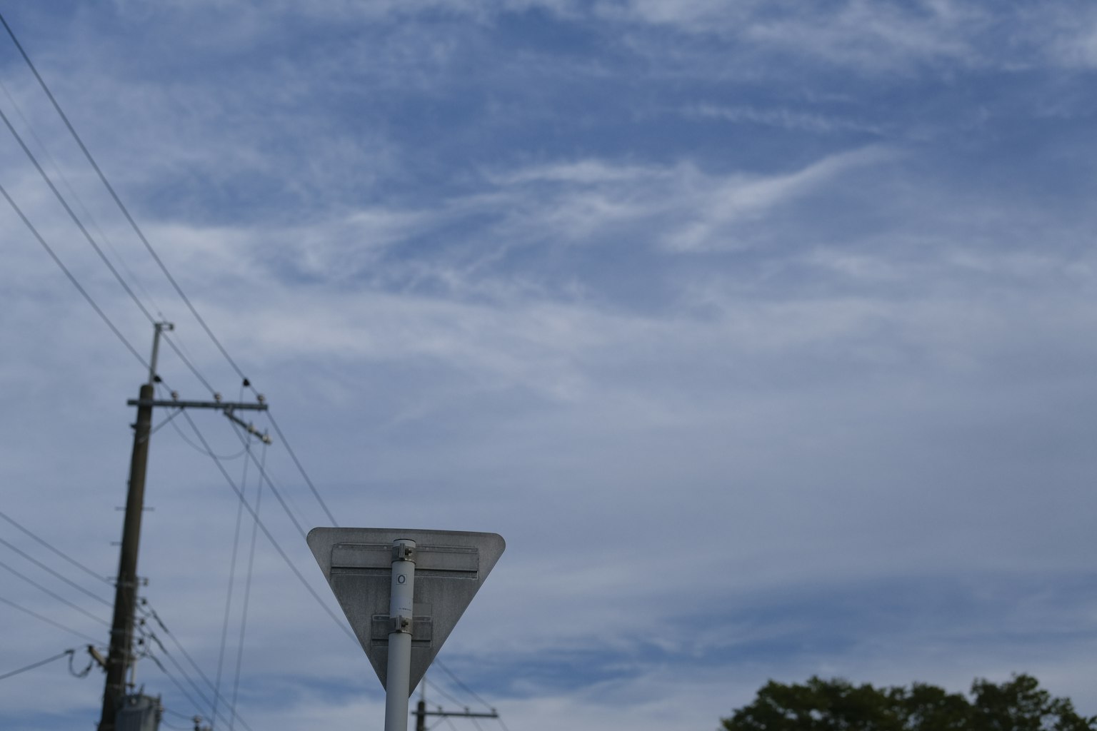 藍天和雲的景色中有電線桿和交通標誌