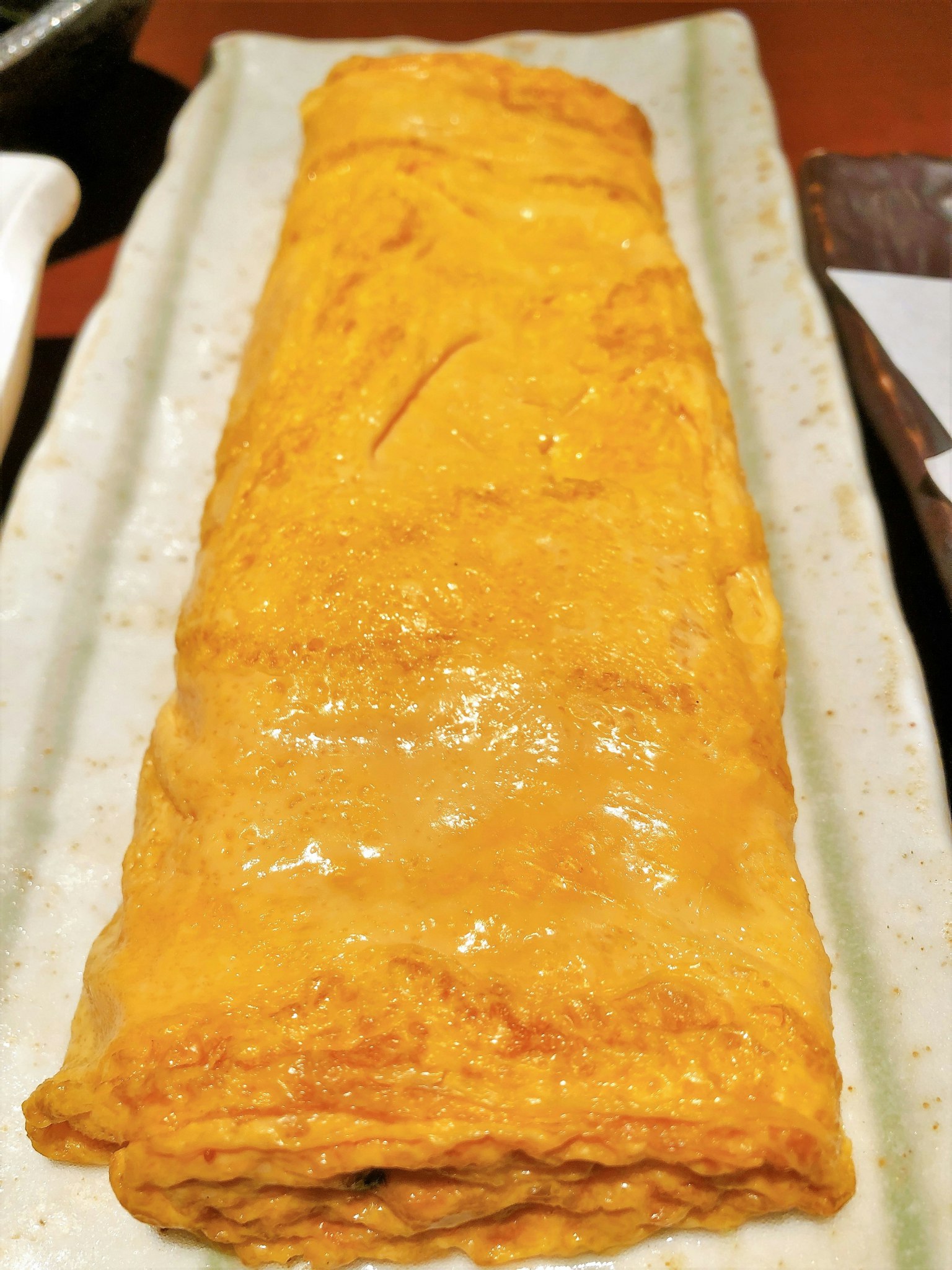 A rolled Japanese omelette served on a plate