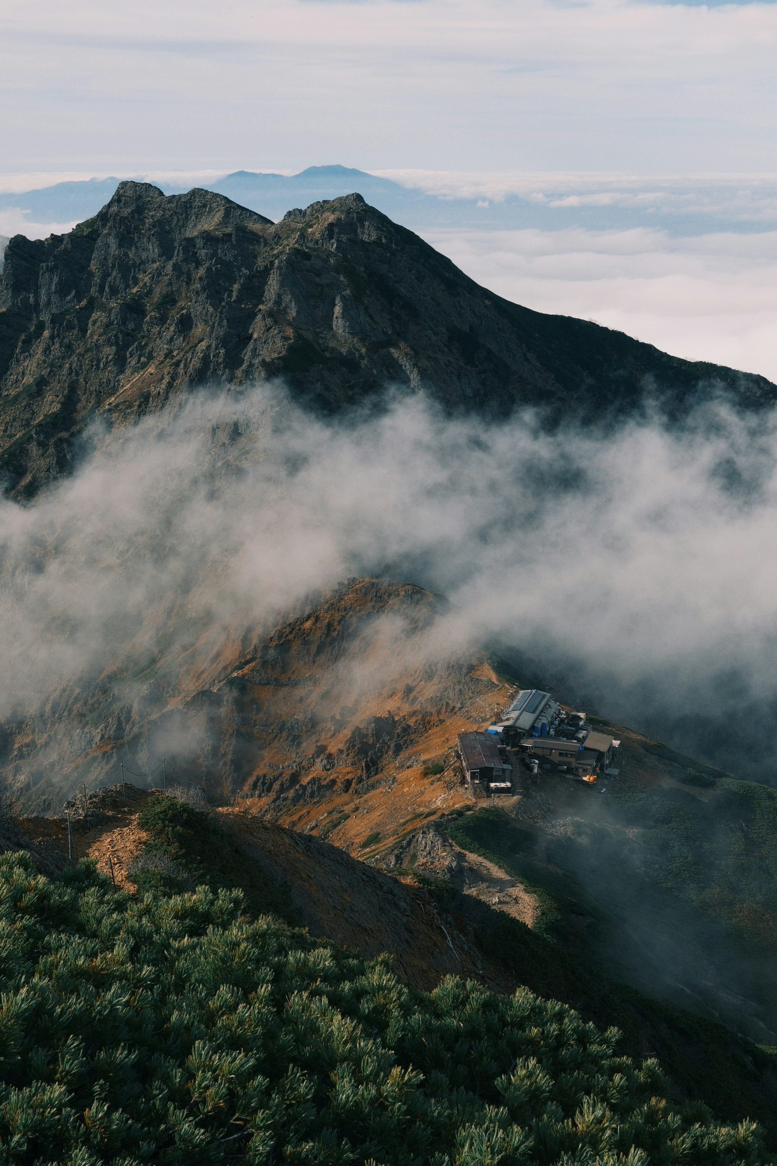雲海に浮かぶ山稜と山小屋のある山の景色