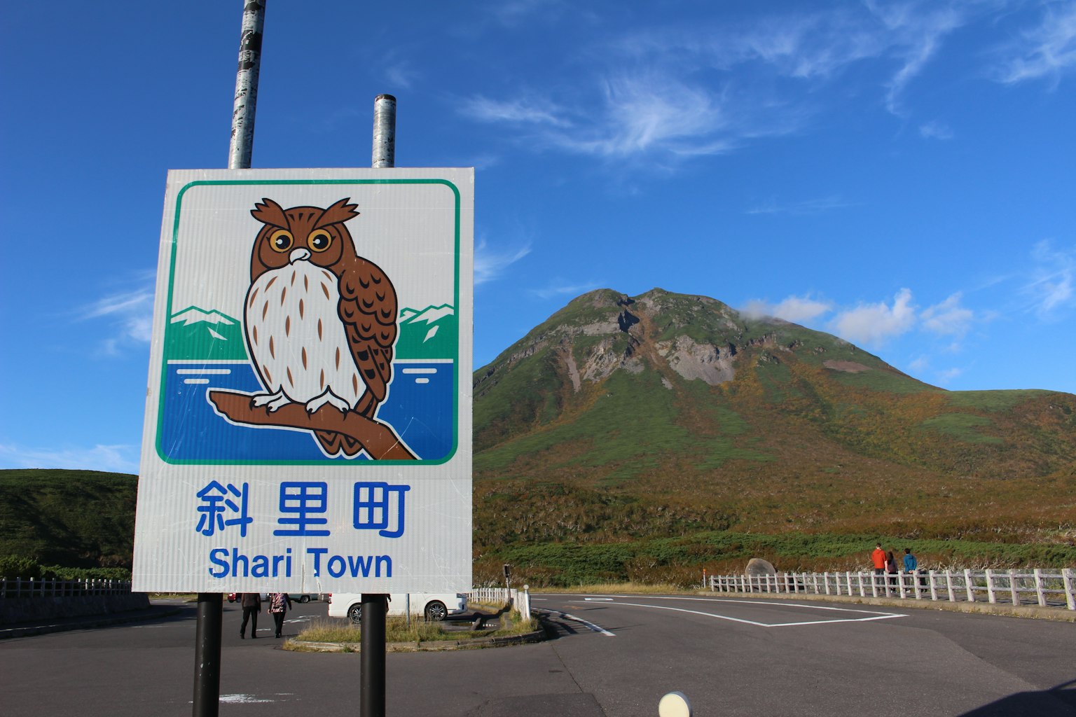 Señal de Shari Town con una ilustración de un búho y una montaña al fondo