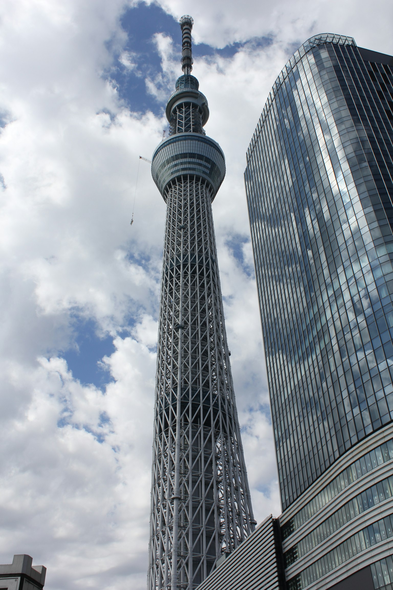 Tokyo Skytree with modern buildings against a cloudy sky