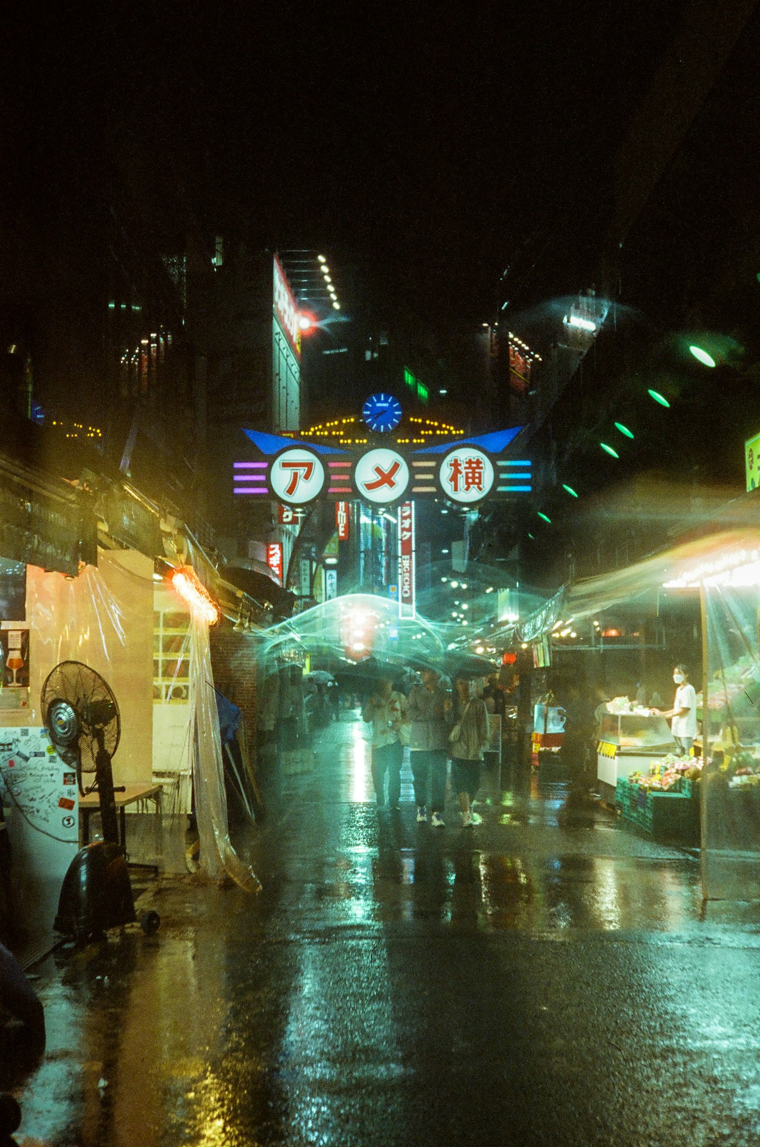 Scène nocturne de la rue Ameyoko animée sous la pluie