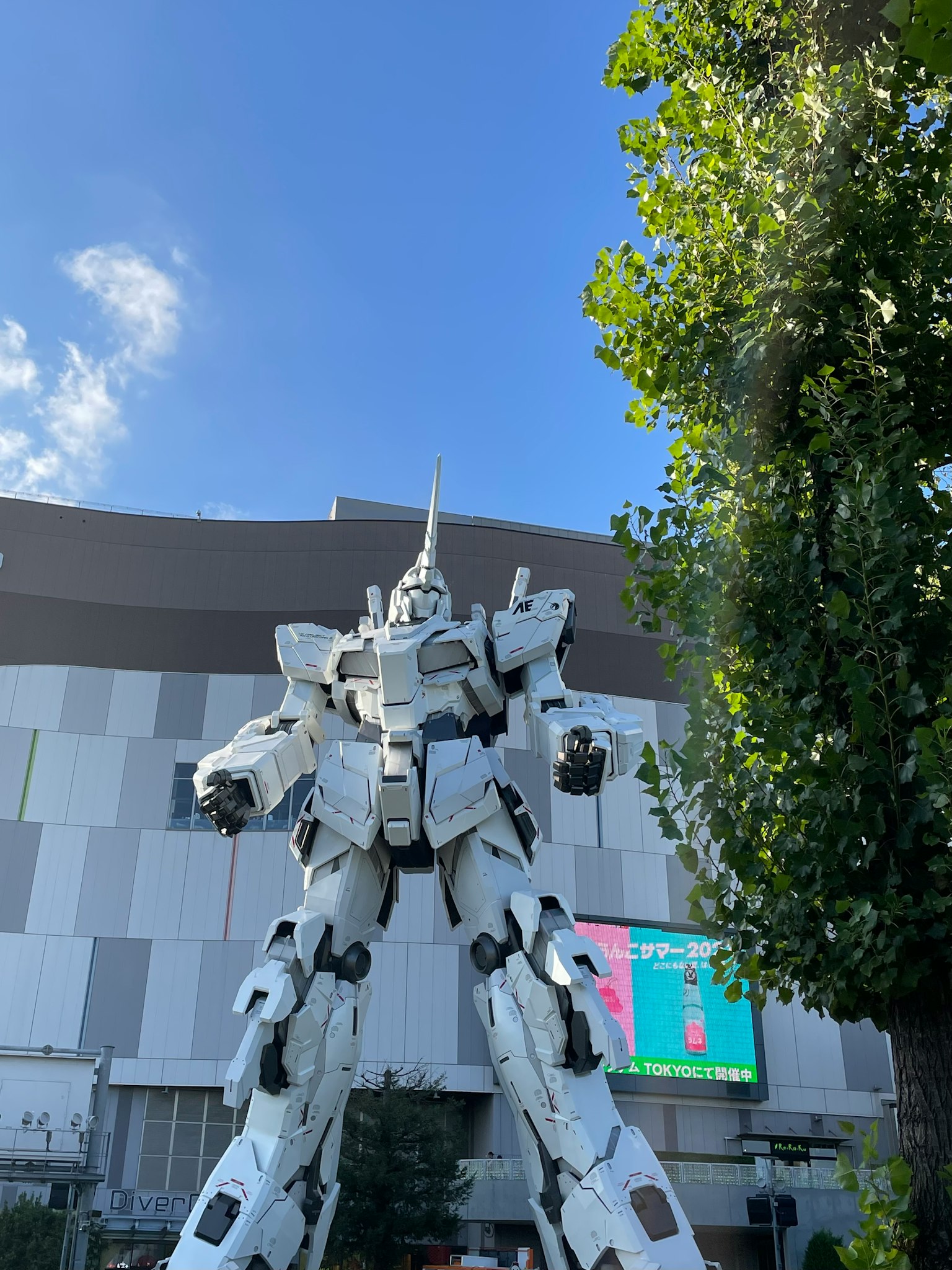 Una statua di robot gigante si erge sotto un cielo blu