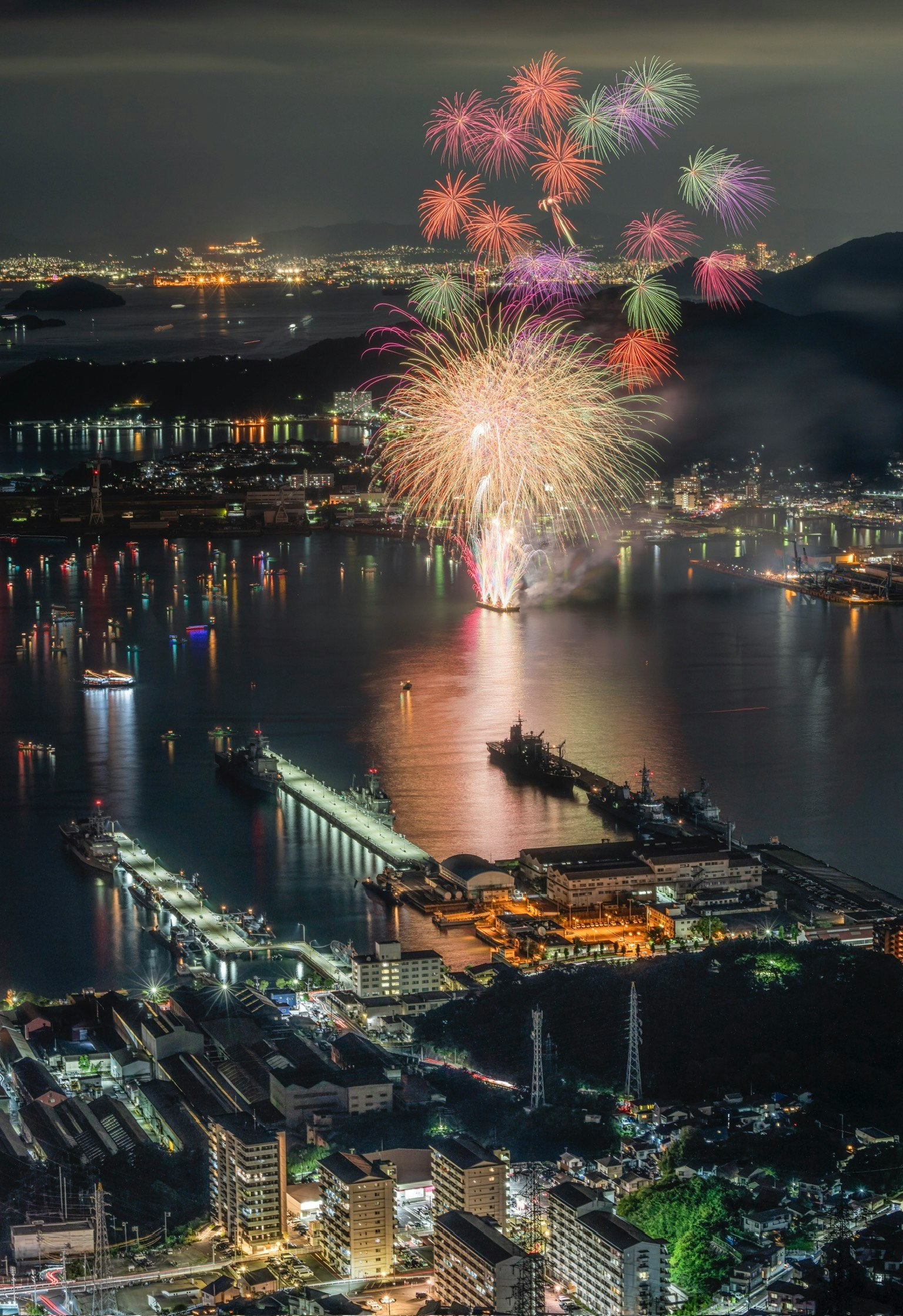 Schöne Aussicht auf Feuerwerk, das sich nachts im Meer spiegelt