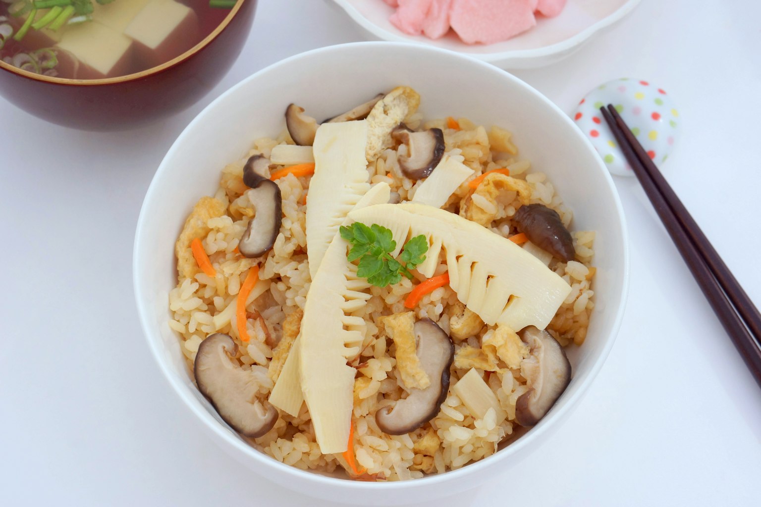 白色碗中的米飯菜餚，上面放有竹筍和蘑菇