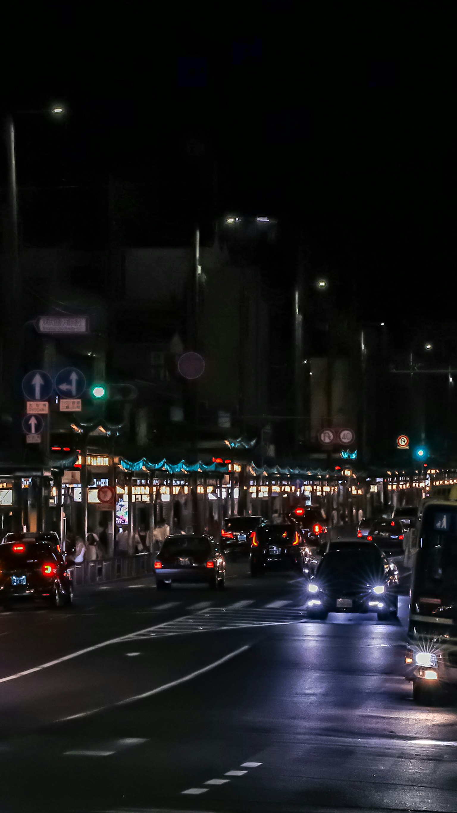 Nächtliche Stadtstraßenszene mit Autoscheinwerfern und Ampeln