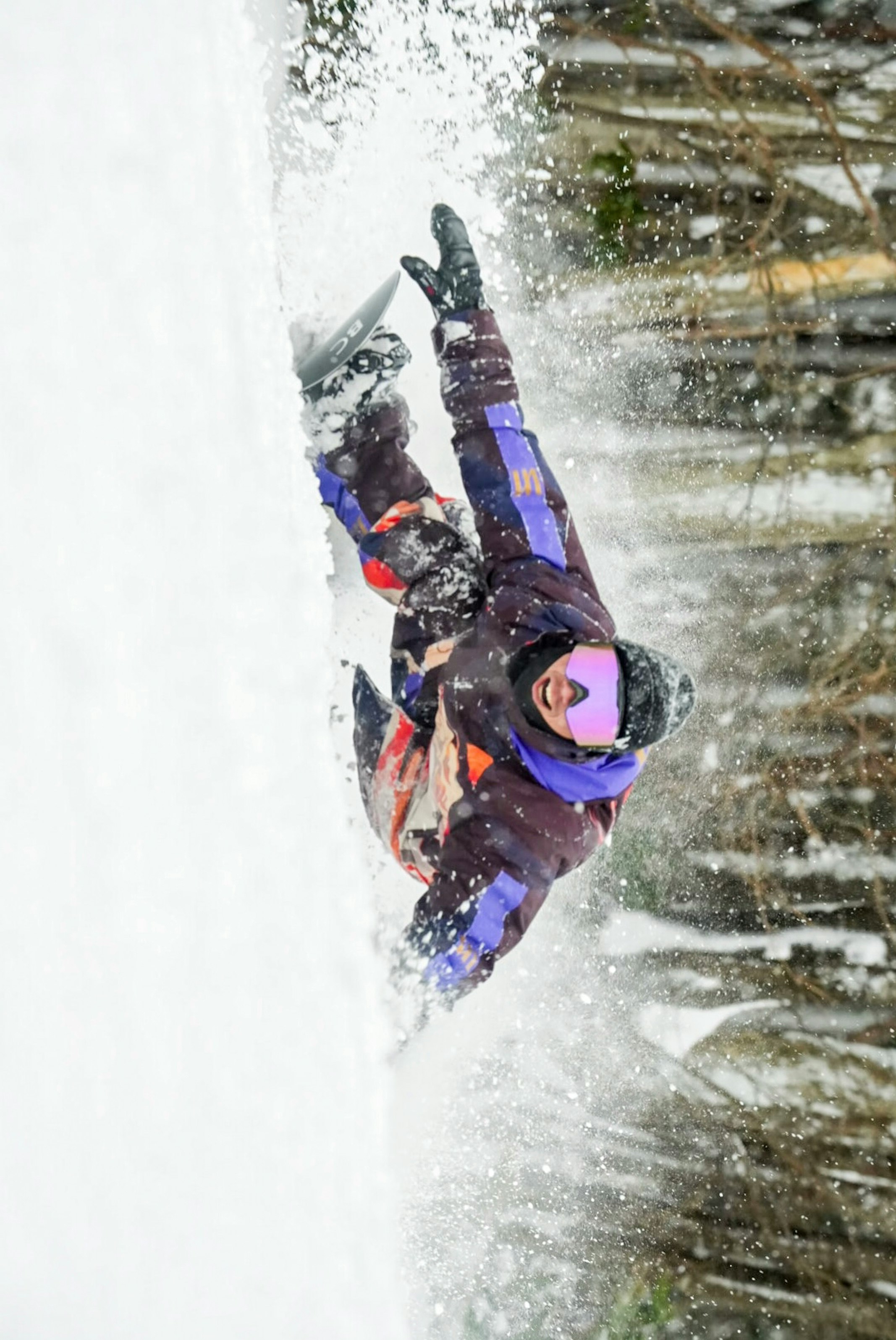 Aksi carving snowboard dengan percikan salju