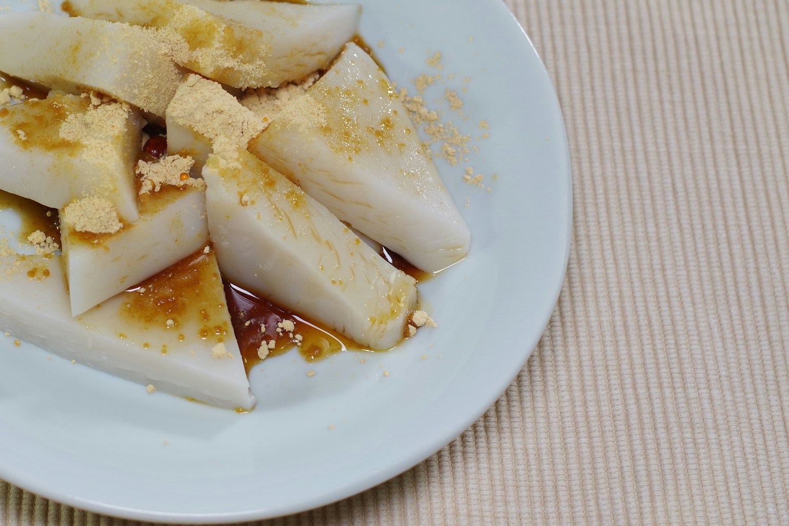 Fette di daikon dolce servite su un piatto bianco con salsa dolce