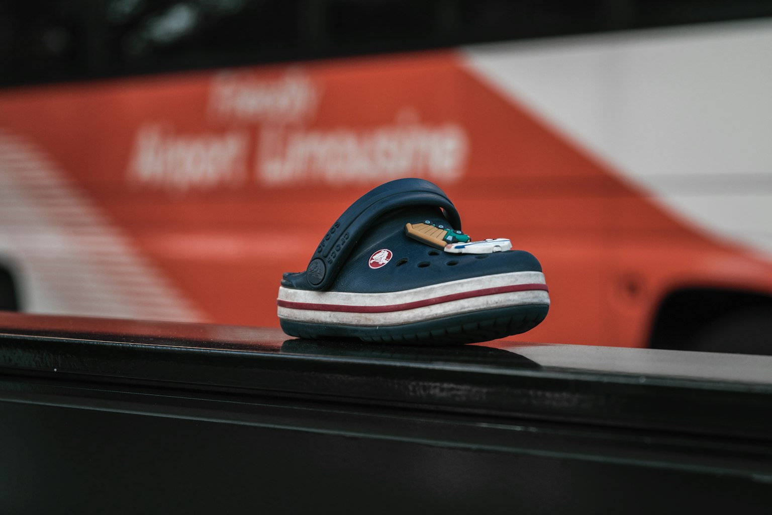 Une chaussure en crocs bleu et blanc posée sur un bus
