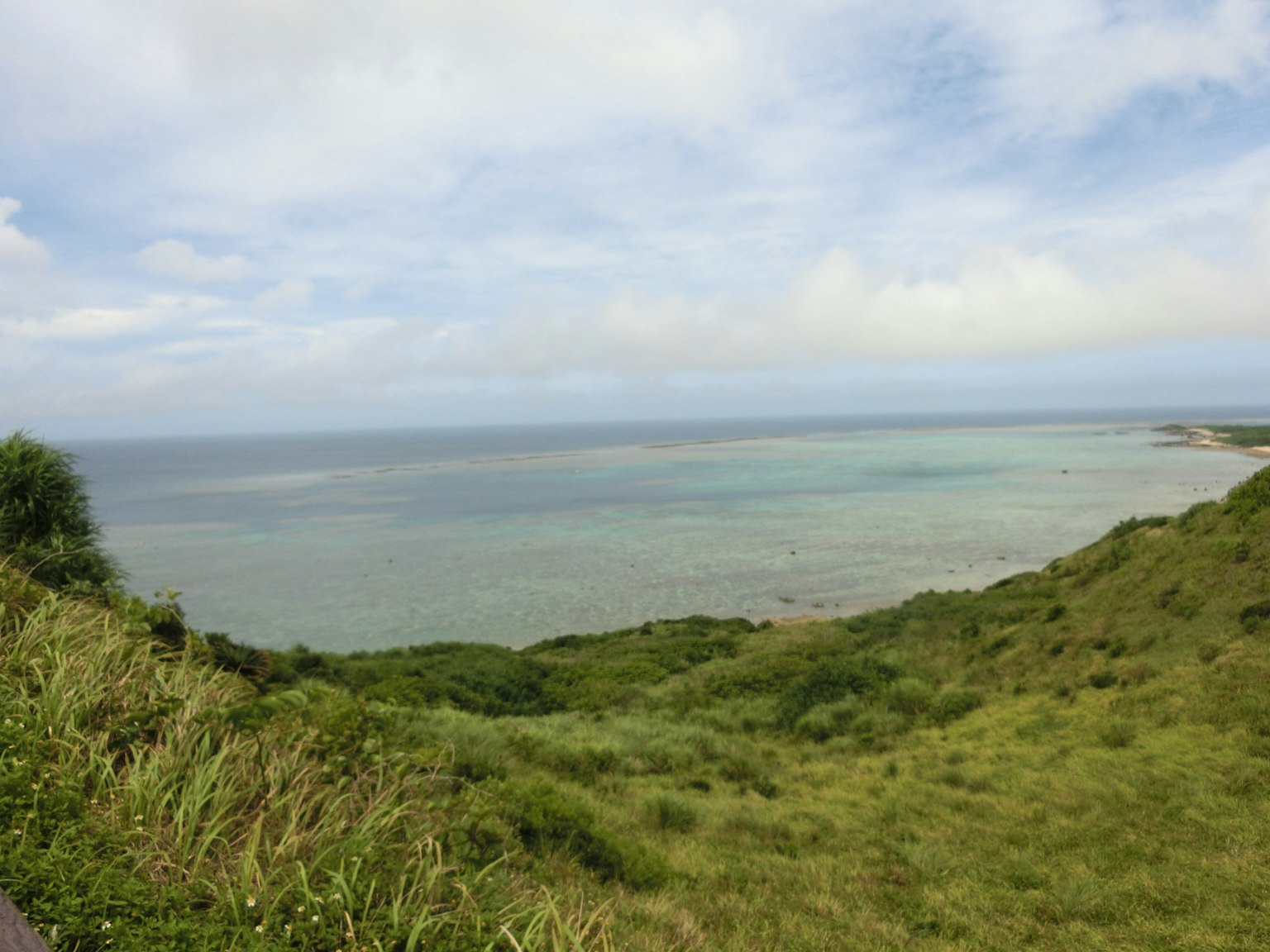 藍色海洋和綠色山丘的風景