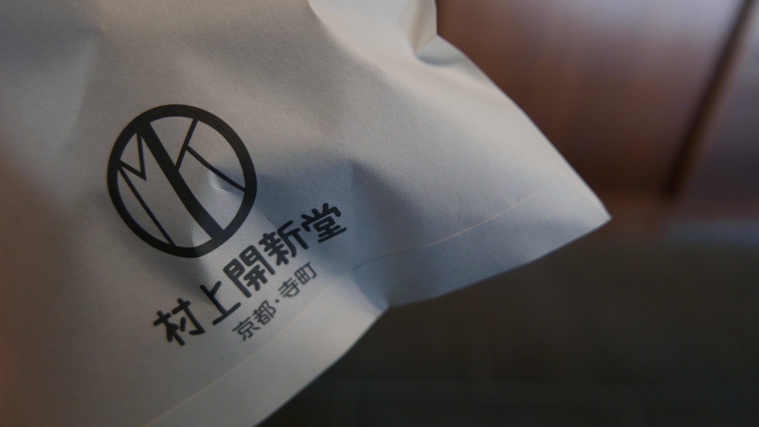 Borsa bianca con logo MK e caratteri cinesi