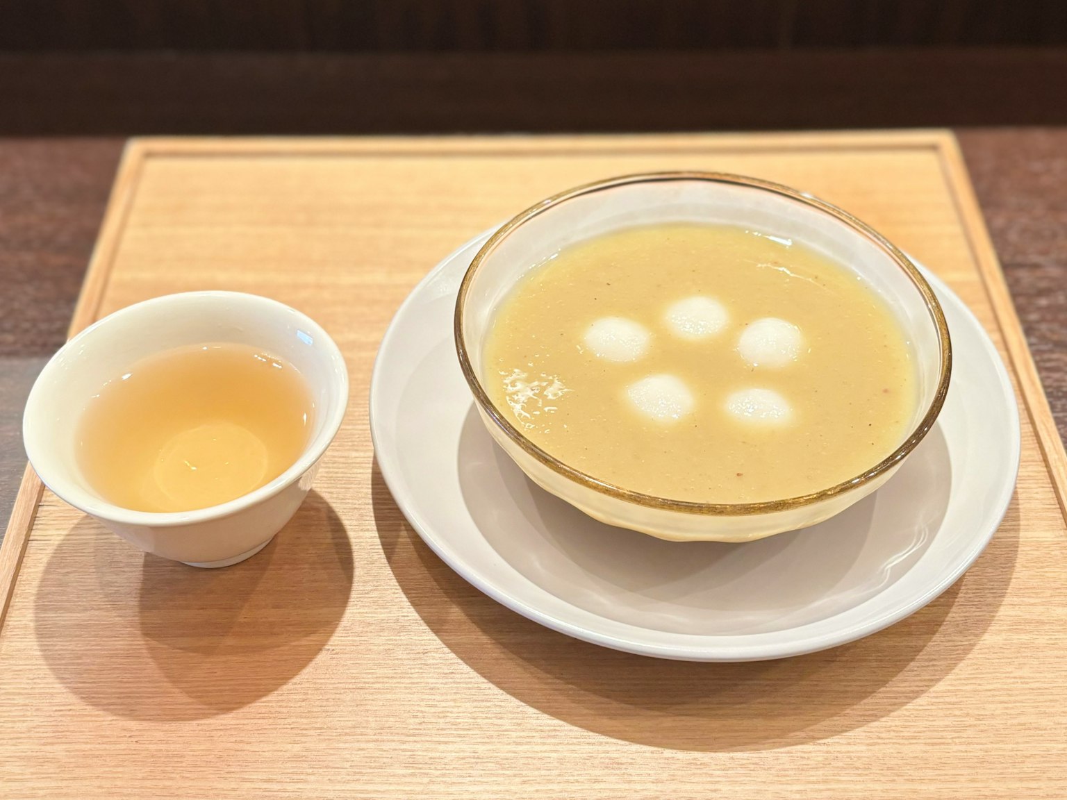 달콤한 수프와 찹쌀 경단이 담긴 그릇과 차 한 잔