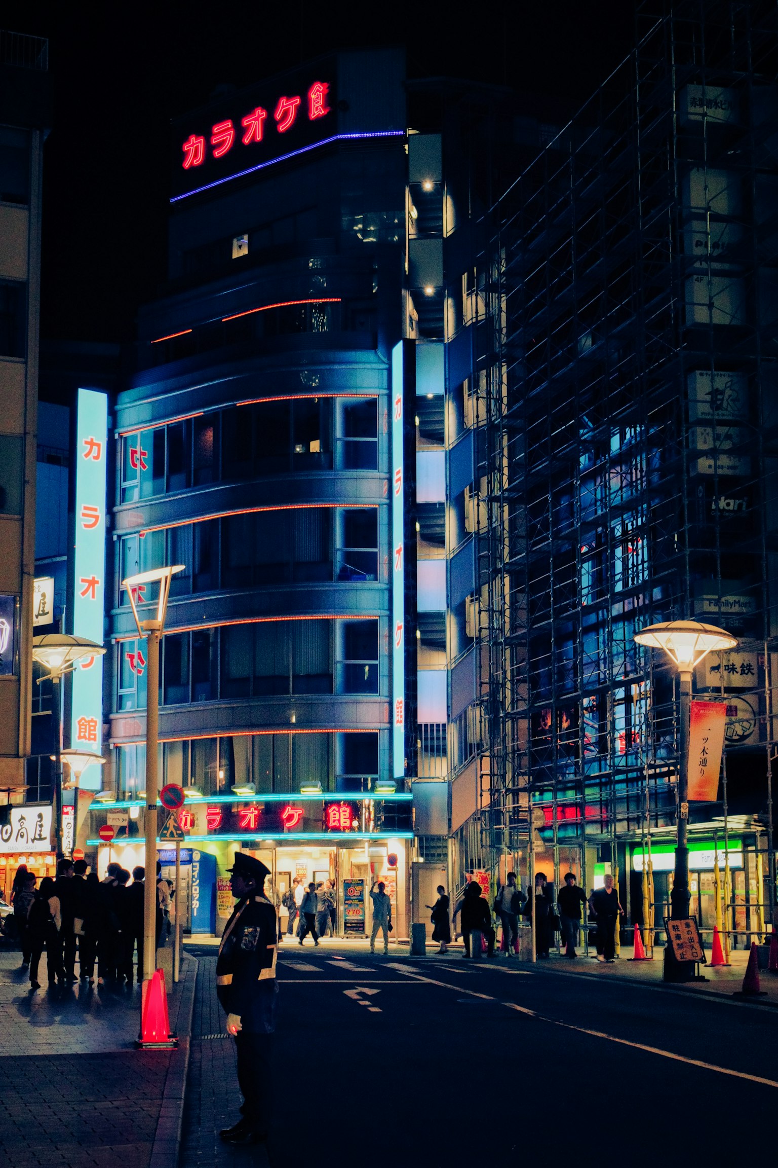 夜間城市景觀，包含卡拉OK建築和行人