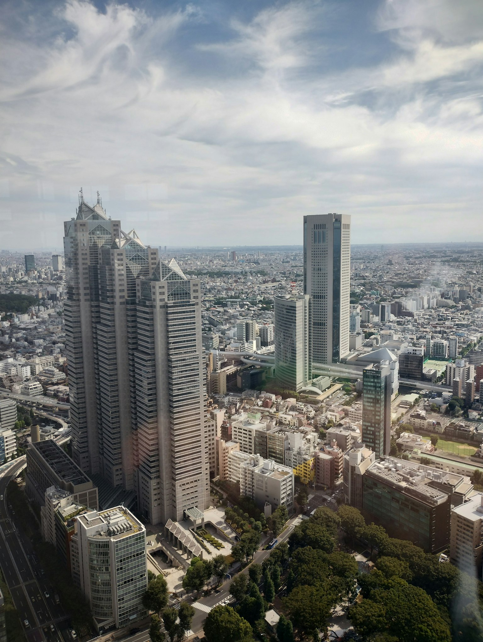 Vista panorámica de los rascacielos de Tokio con cielo azul y nubes
