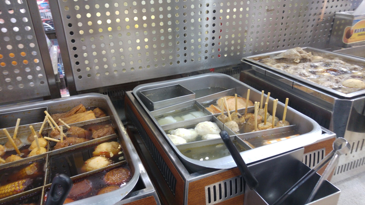 Stand de nourriture de rue affichant divers articles frits et brochettes