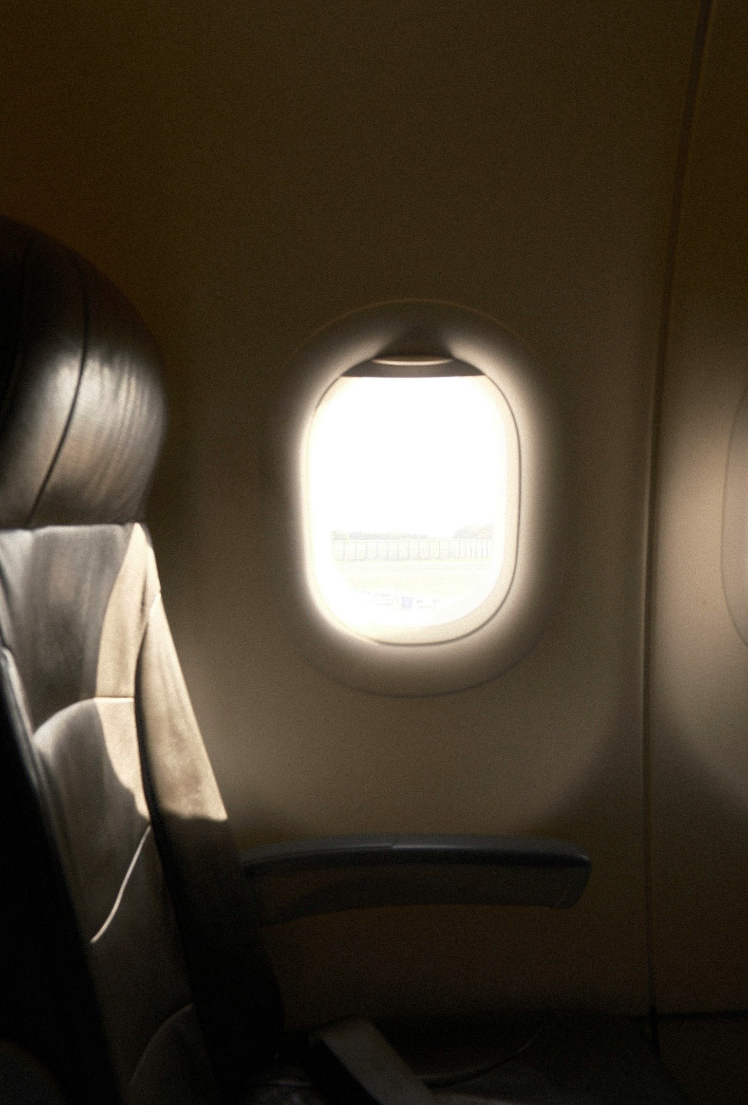 飛行機の窓からの光が差し込むシートの側面