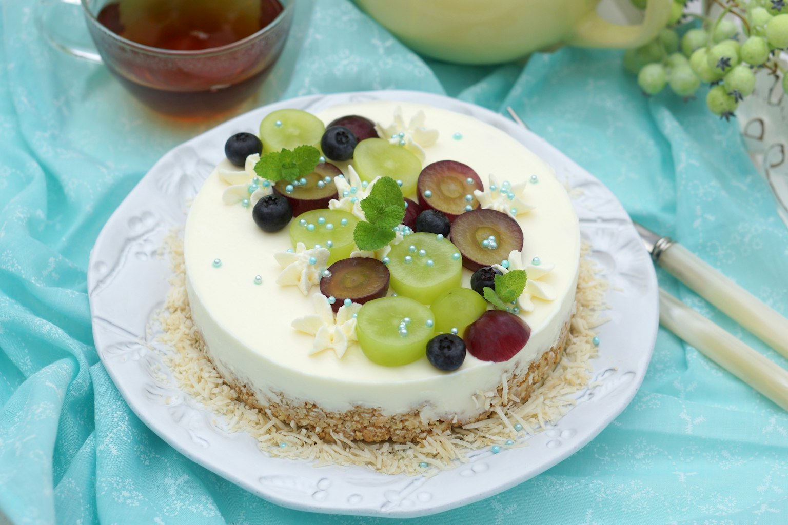 Cheesecake crémeux garni de fruits colorés, y compris des raisins et des bleuets