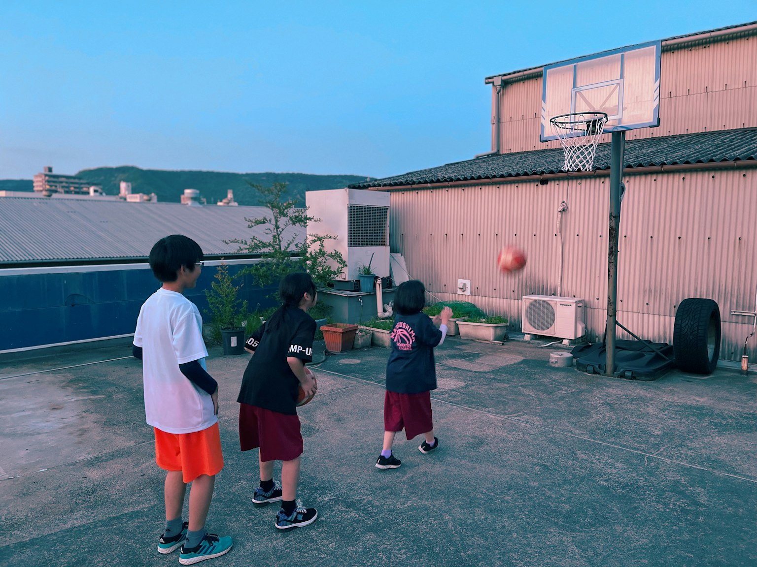 Grupo de niños jugando baloncesto en una azotea