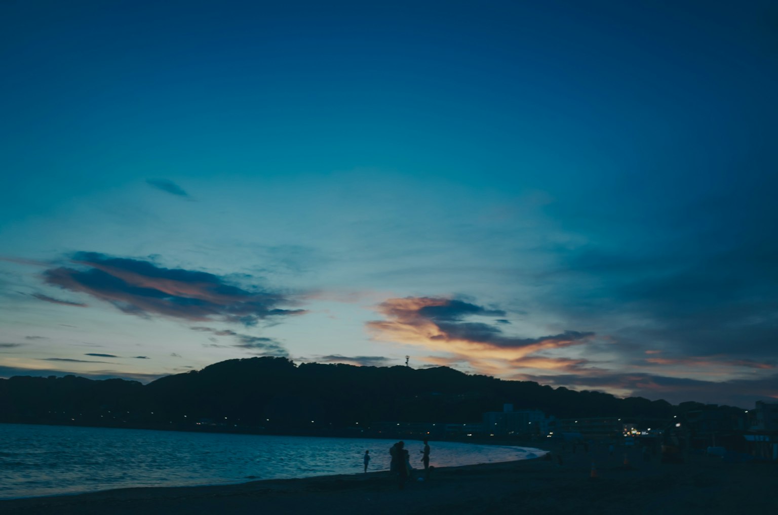 Silhouette der Küste und Berge bei Dämmerung mit buntem Himmel
