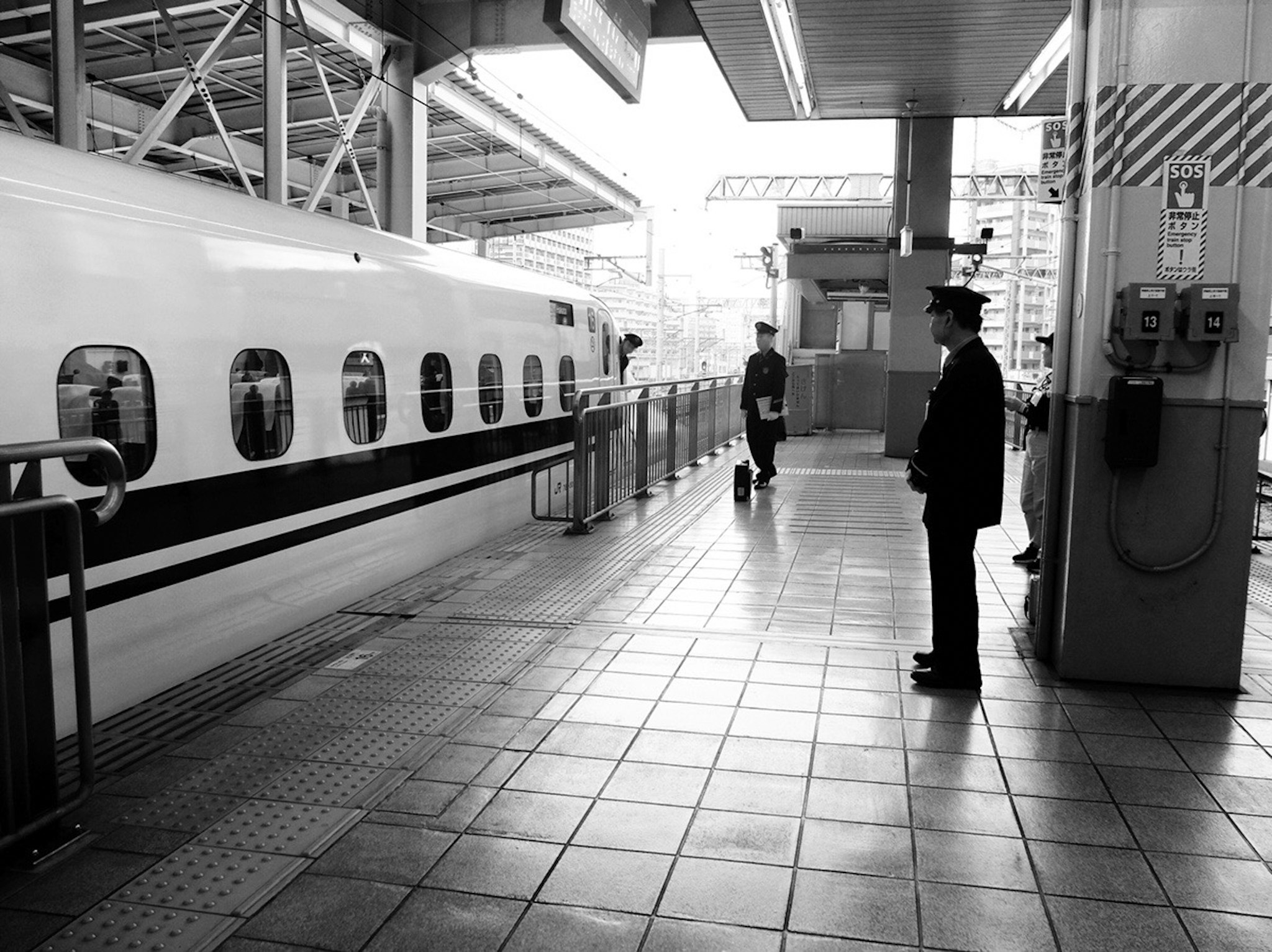 koridor peron stasiun dengan orang berseragam berdiri di dekat kereta