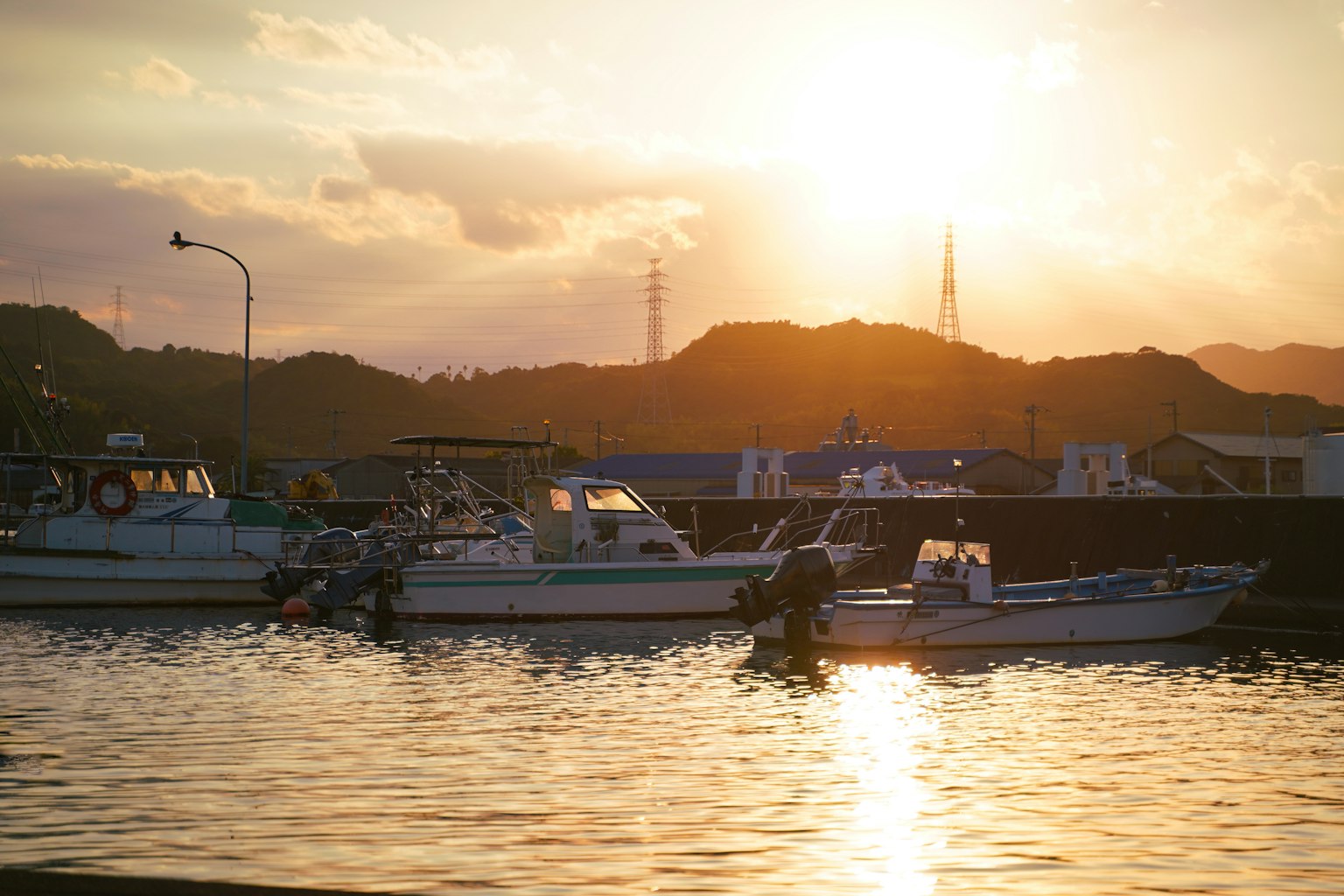 Boats floating on a calm surface during sunset