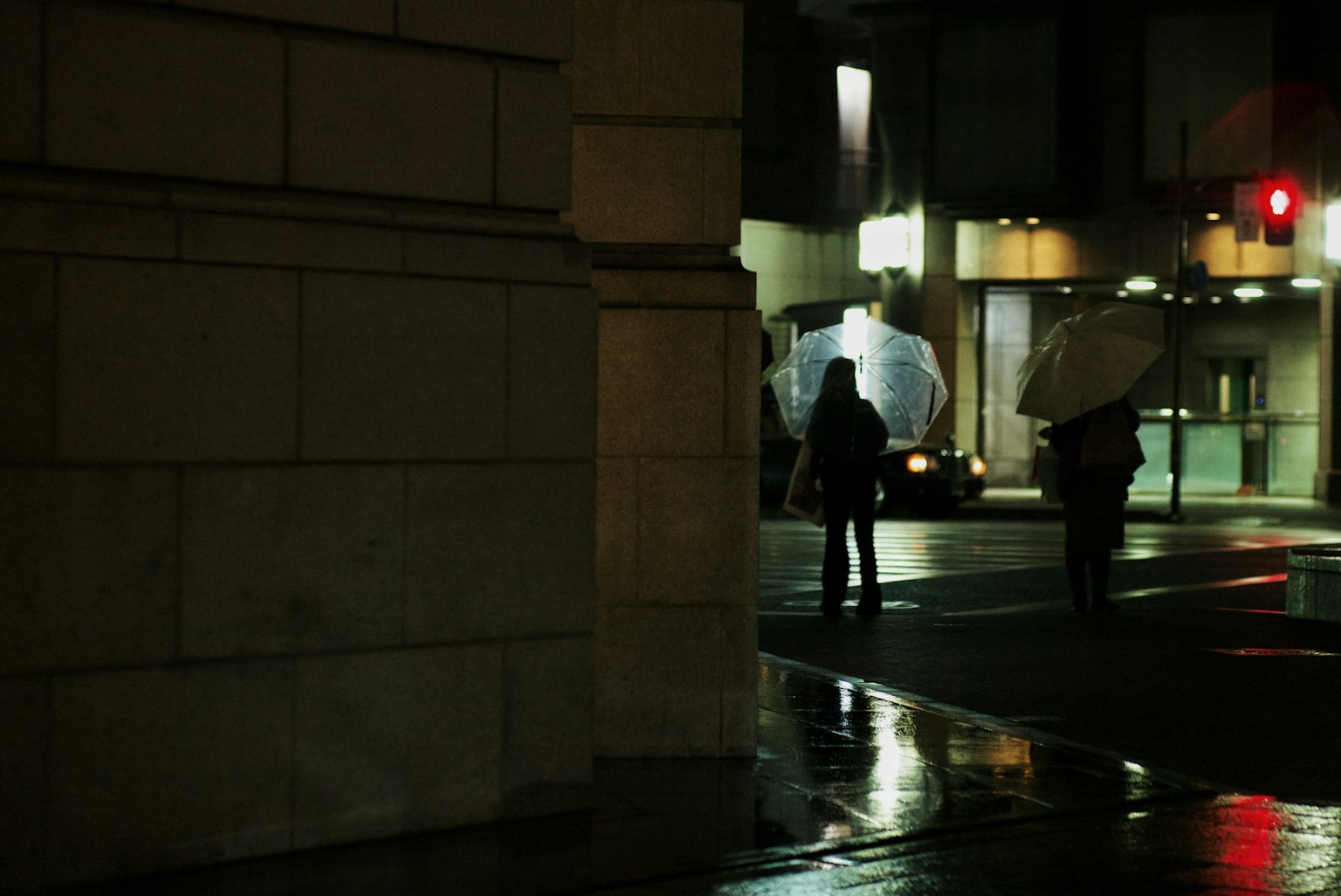 两个人在夜间持伞过马路