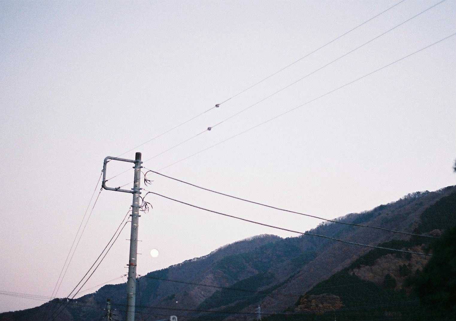 crêtes de montagne avec poteaux électriques et lignes aériennes au crépuscule