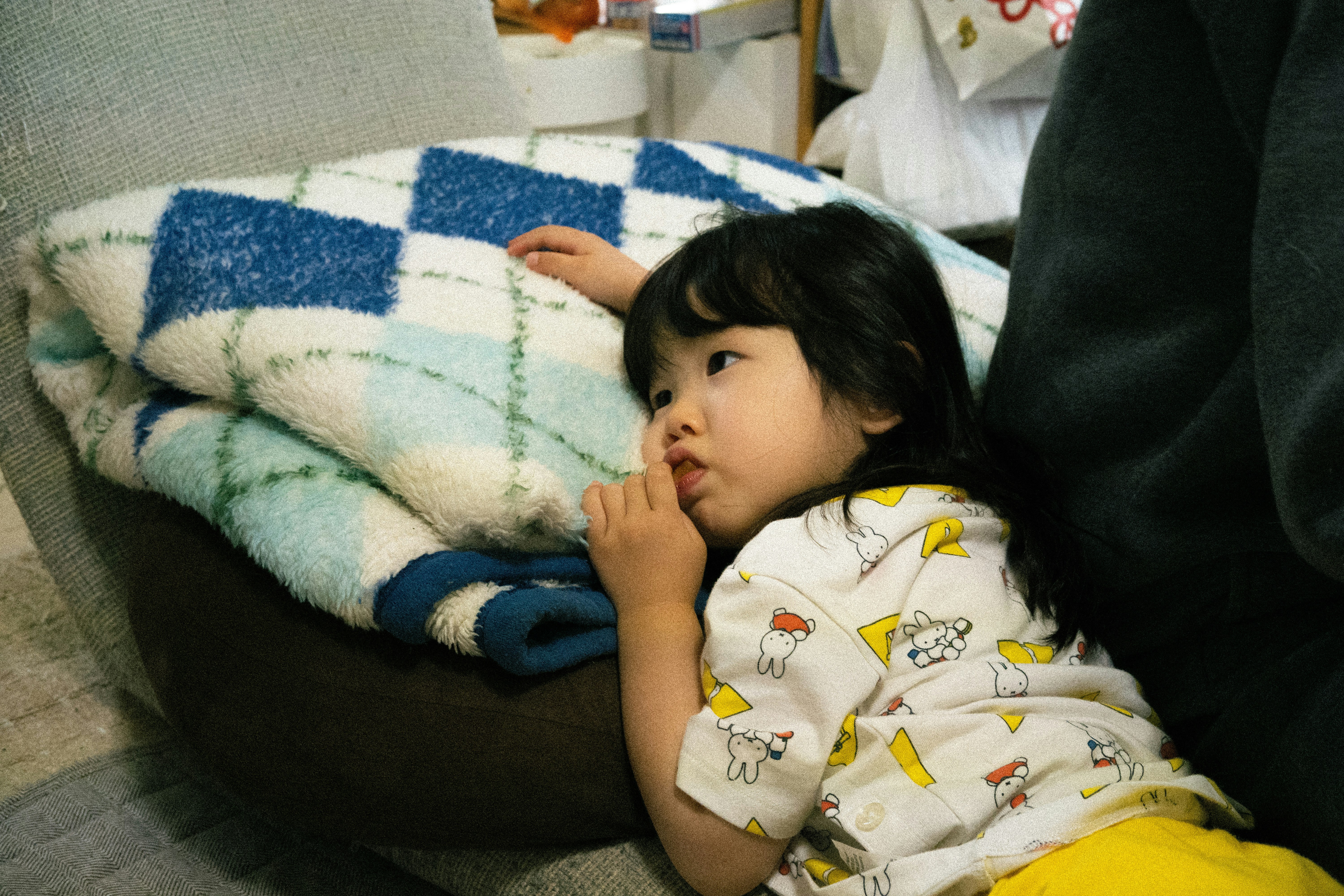 Ein Baby in eine Decke gewickelt auf einem Sofa