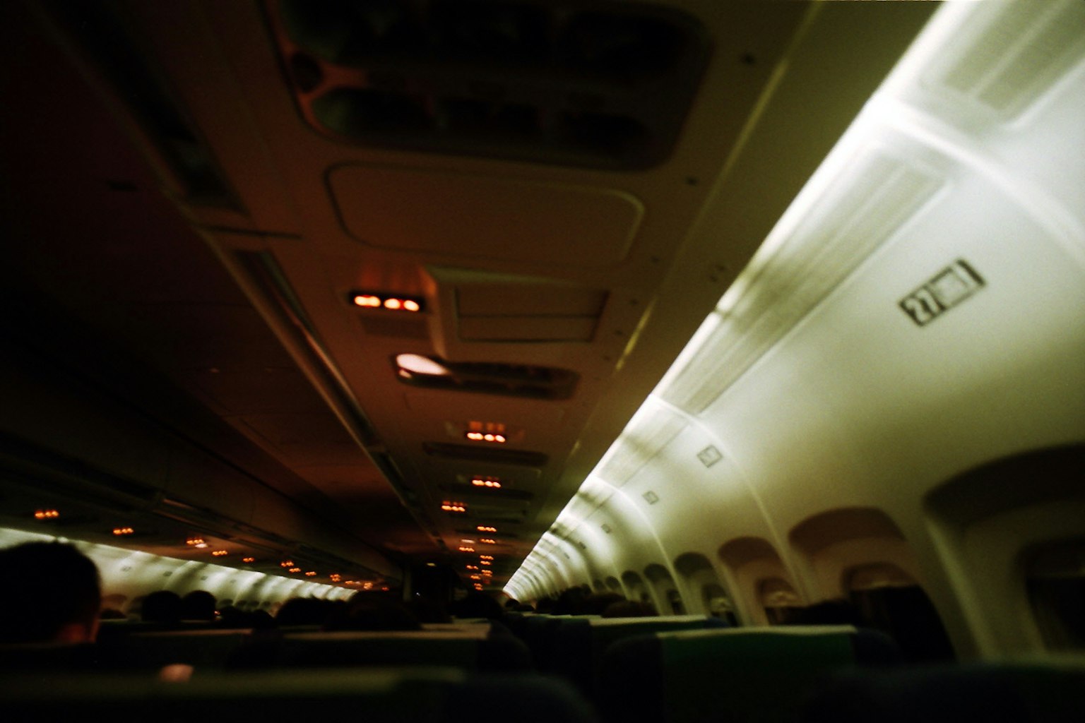 Interior of an airplane with dim lighting and rows of seats