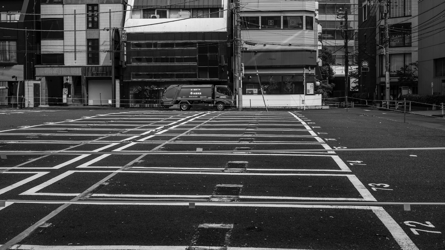 Empty parking lot with surrounding buildings in black and white