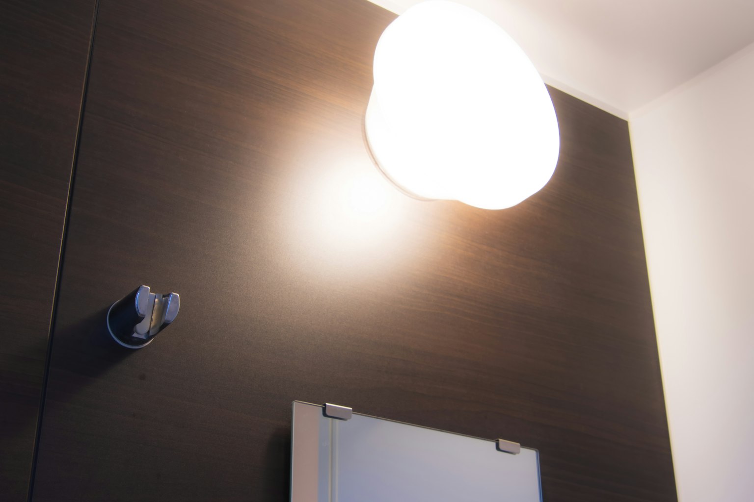 Interno semplice con una luce rotonda al soffitto e uno specchio sulla parete