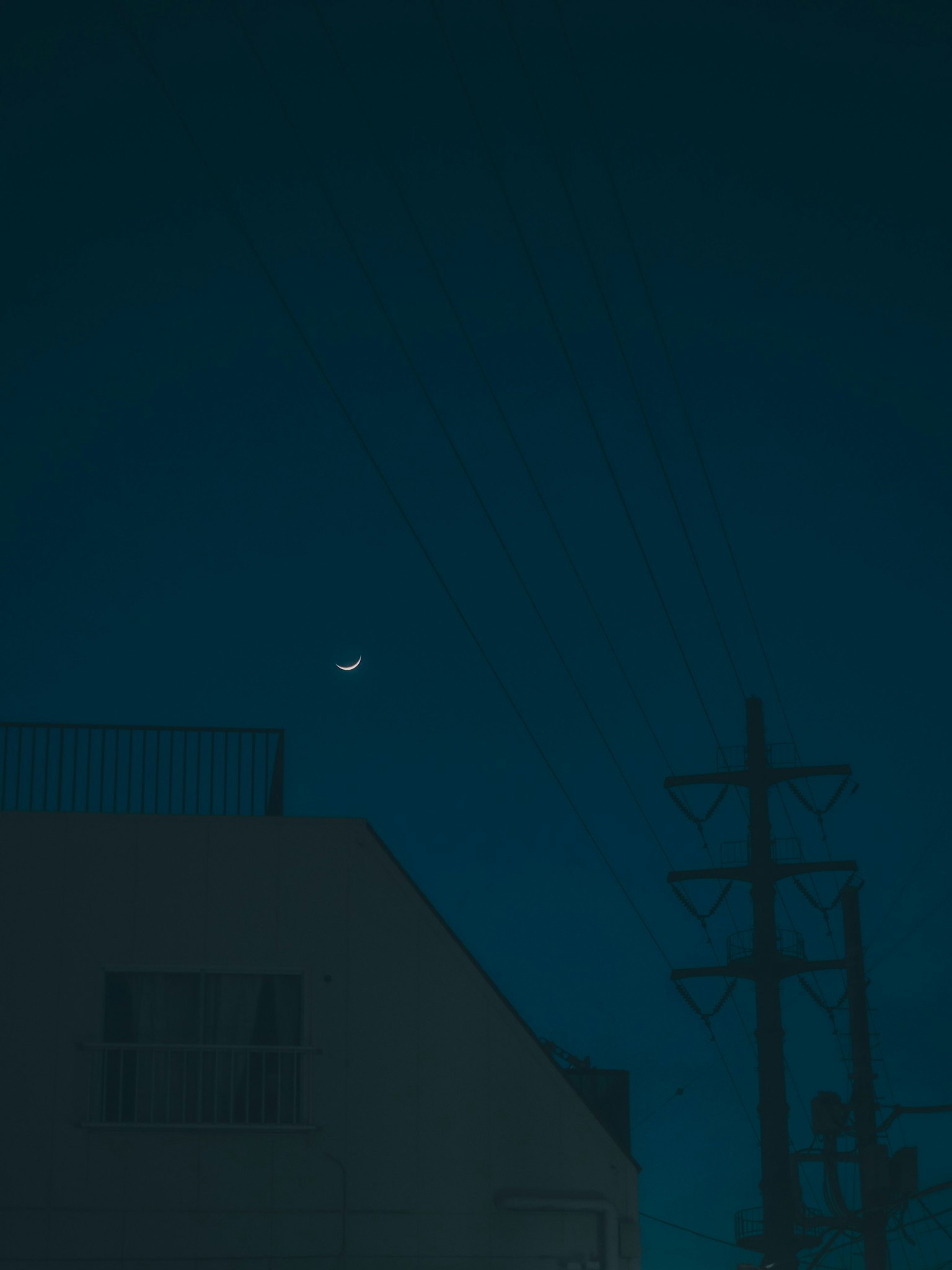 Lune croissante dans le ciel nocturne avec silhouette de bâtiment