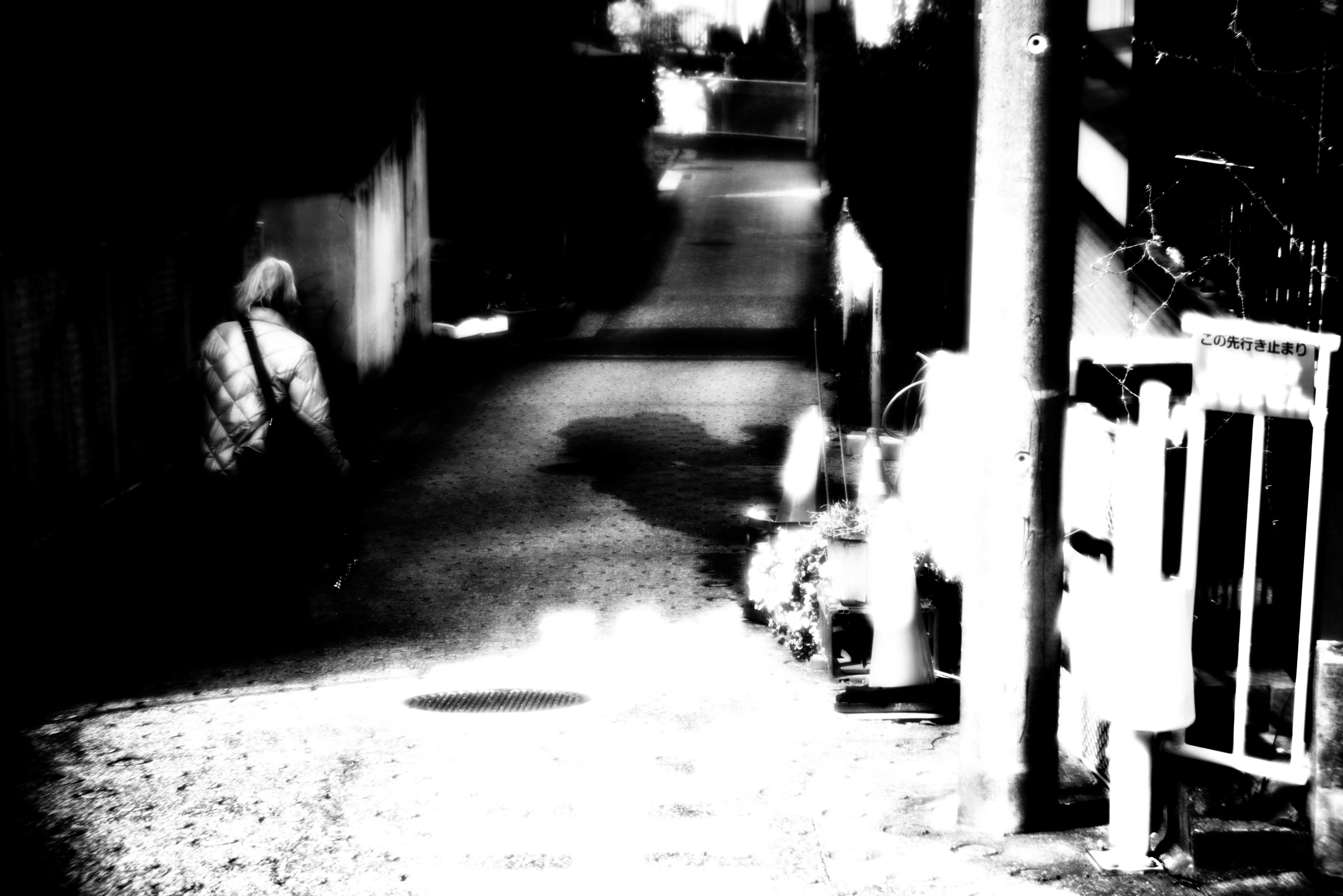 night alley with storefront signs and distant silhouettes