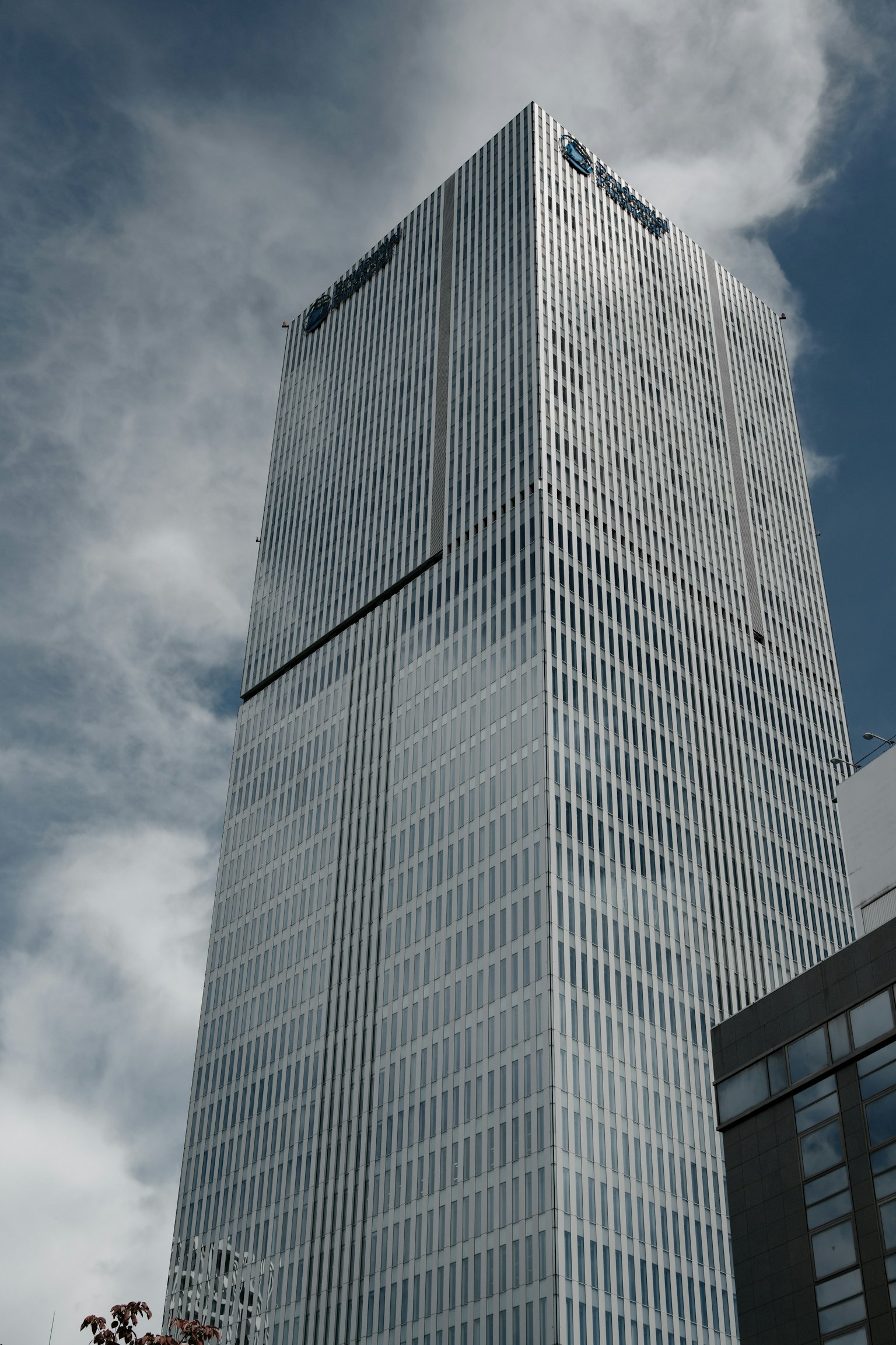 Close-up of a skyscraper under a blue sky featuring modern architecture