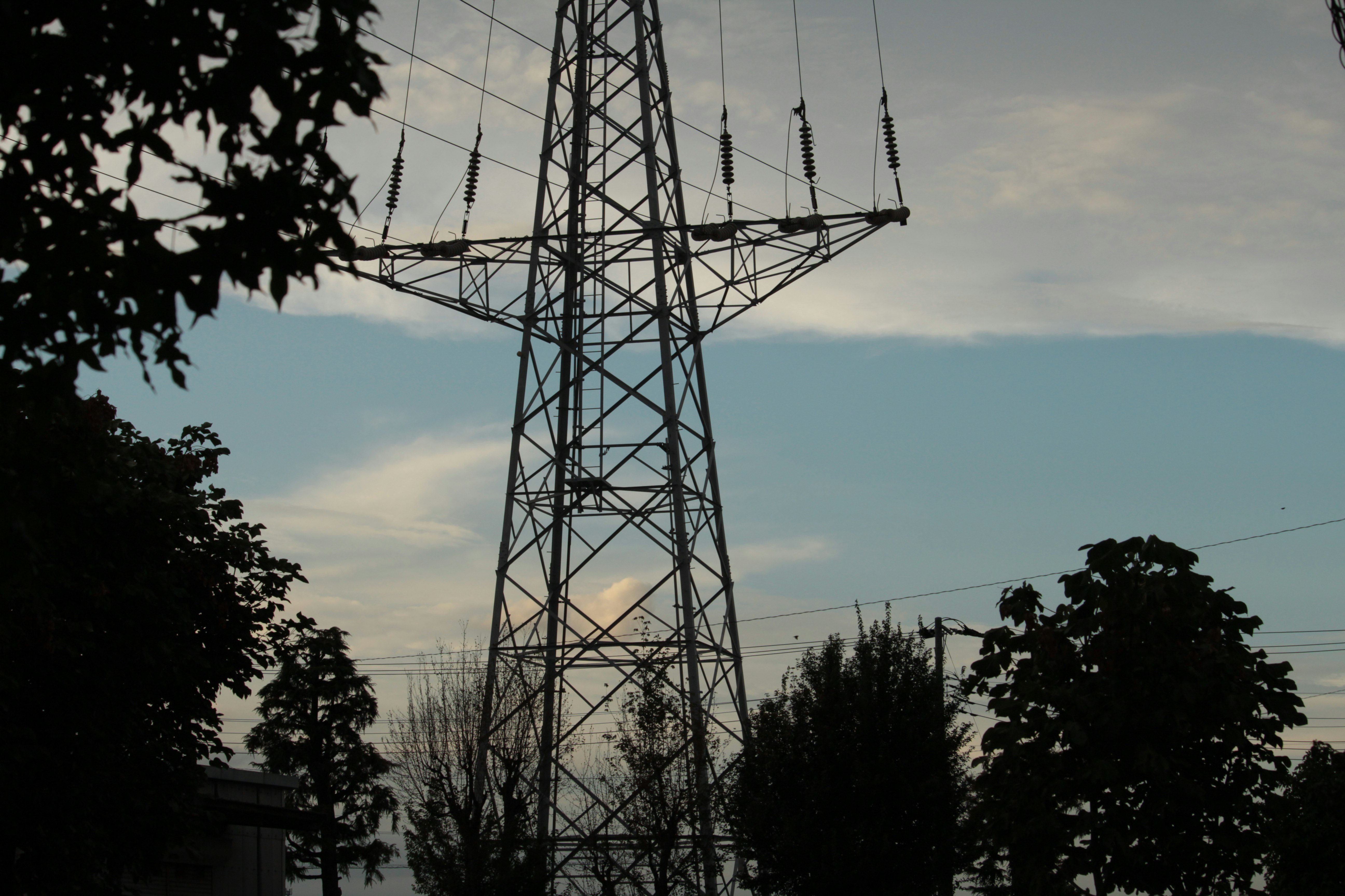 torre de transmisión eléctrica y cables aéreos al atardecer