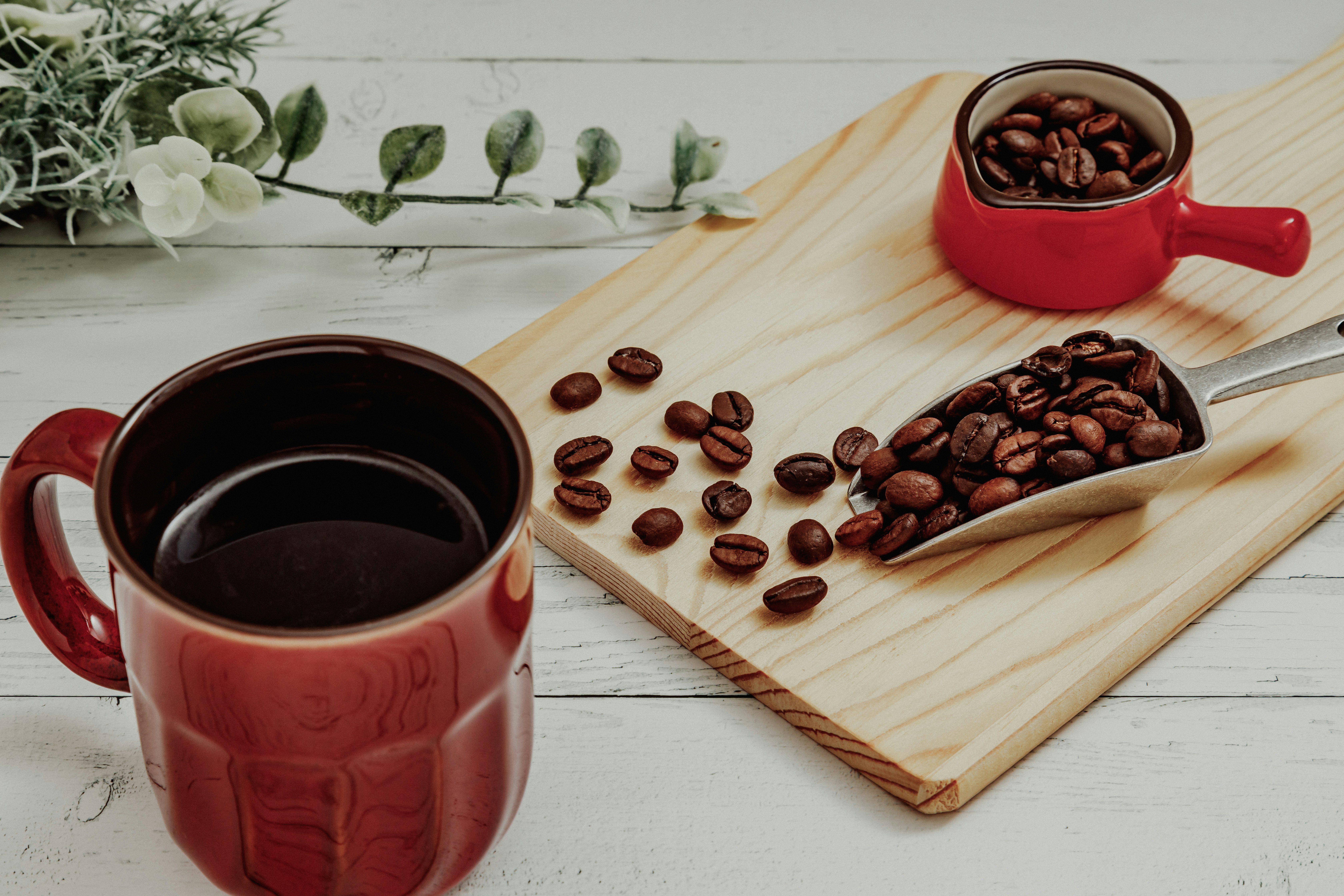 coffee scene with a red mug and coffee beans on a wooden board